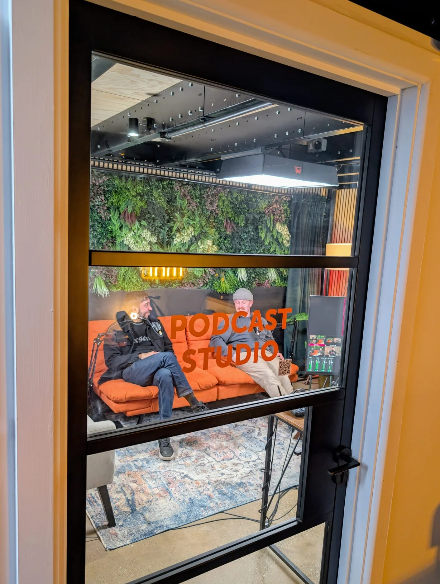 Short Form Studios podcast recording studio exterior view showing Studio 1 session in progress through window in Watford