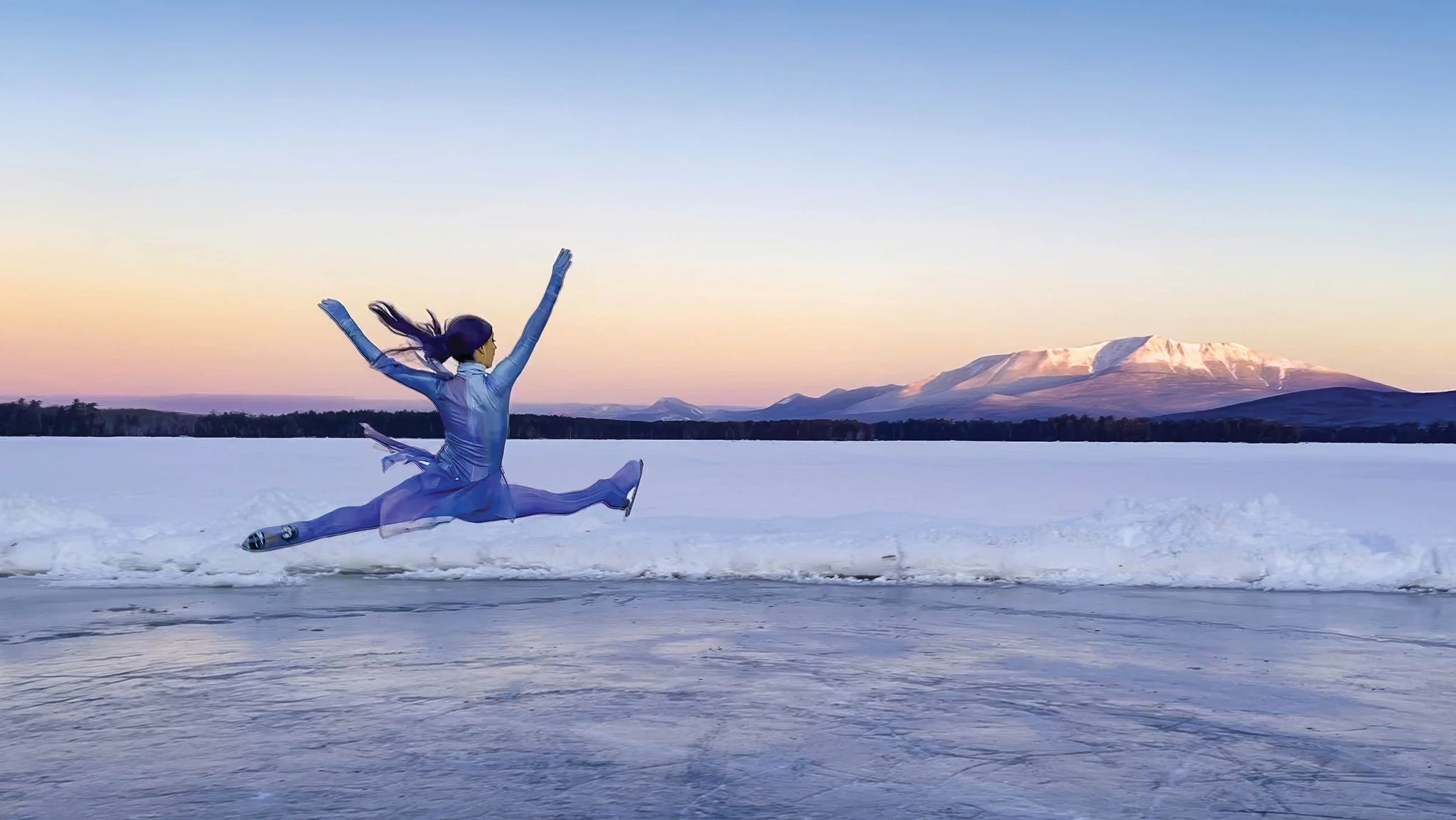 Ice skater jumping on an outdoor rink with mountains in the background.