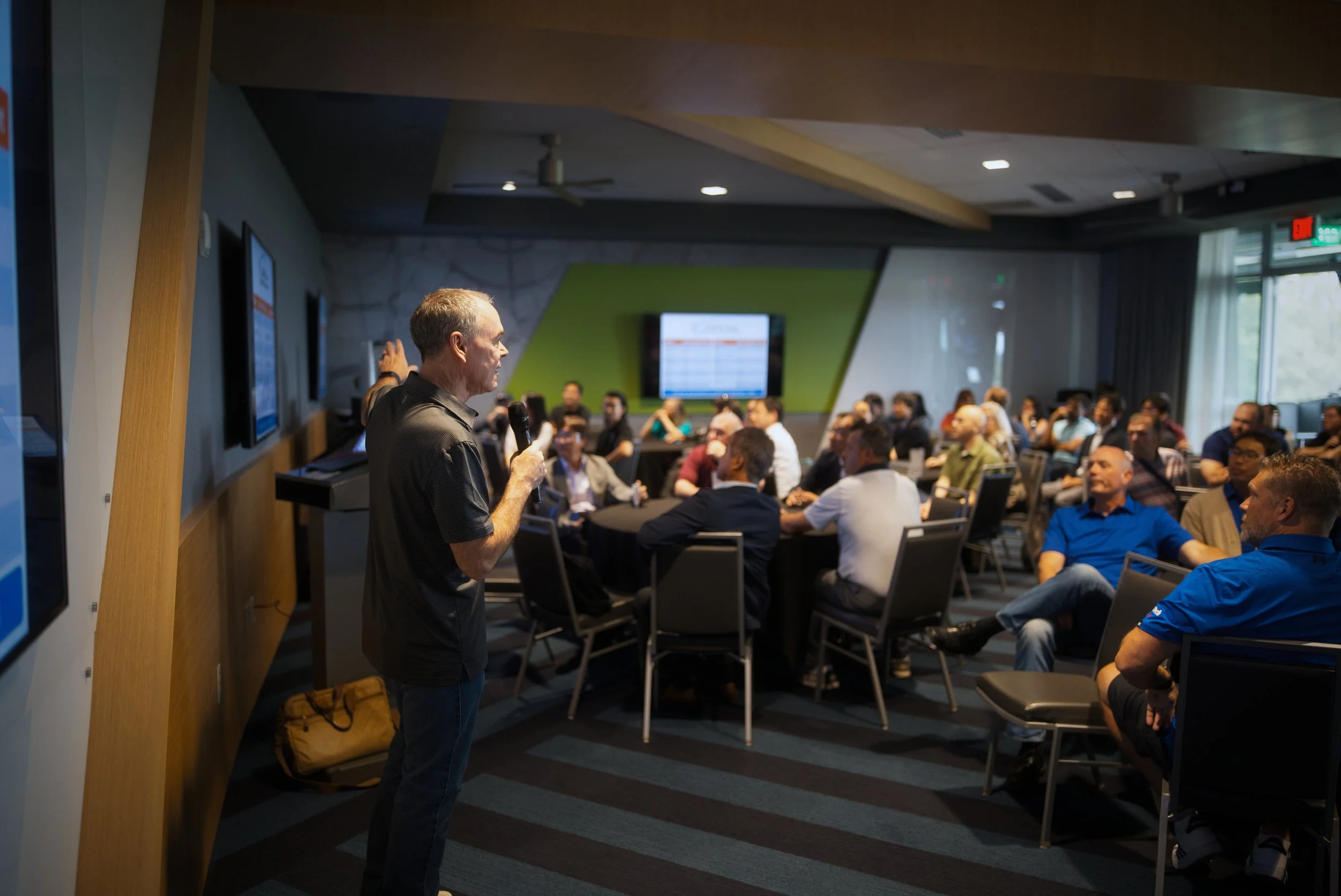 Professional photographers capture manager speaking to employees at a corporate conference event.