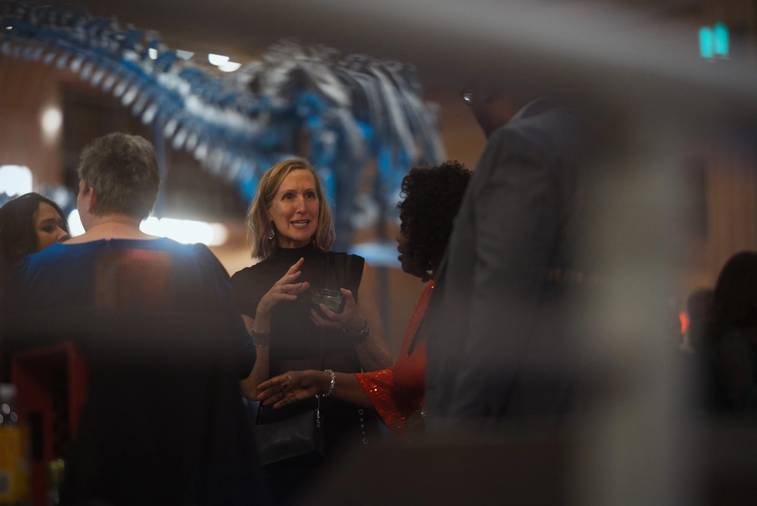 Large company gala with employees in a beautiful museum setting with dynamic lighting.
