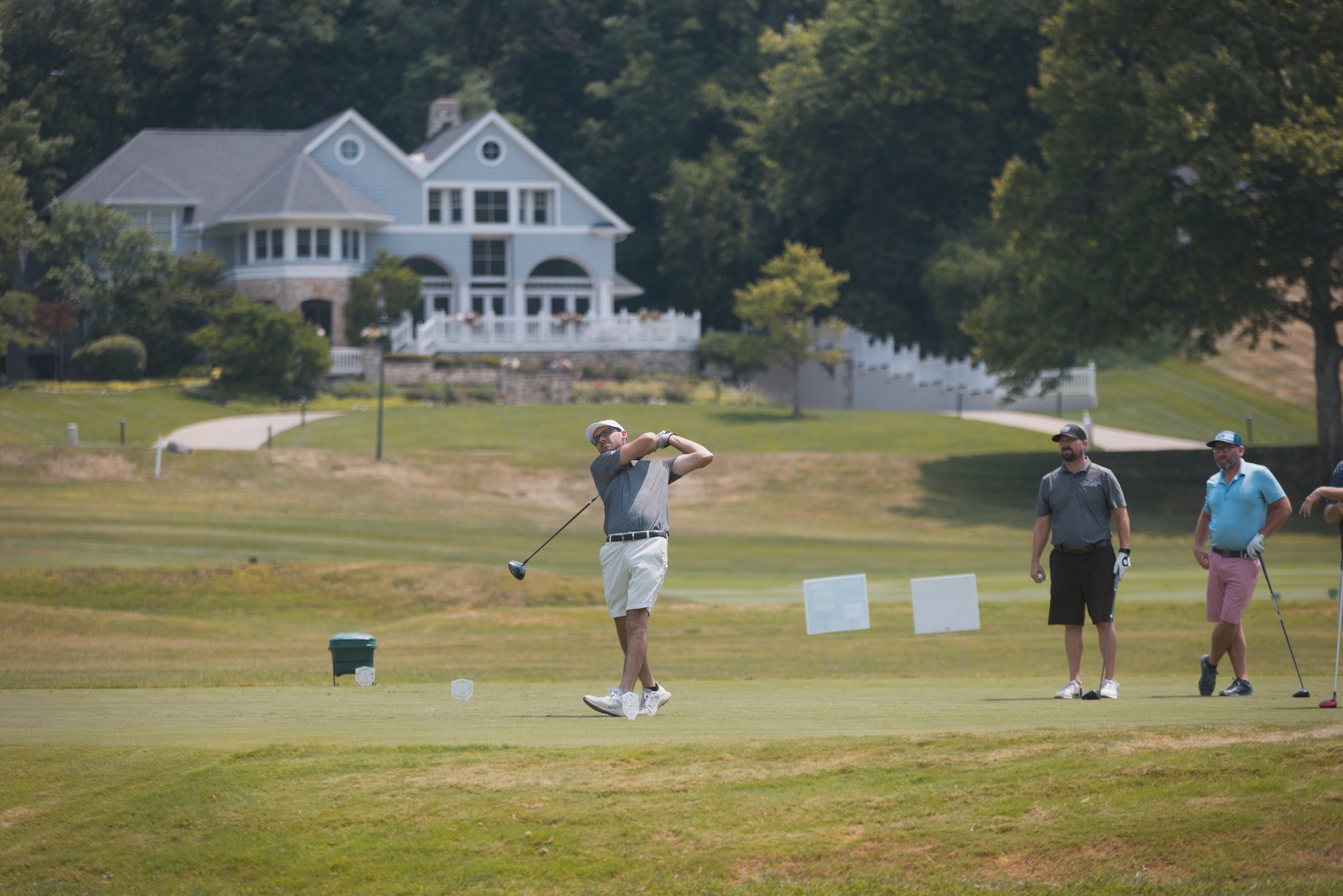High-speed, dynamic action shot of attendee at a charity golf event in a beautiful outdoor setting.