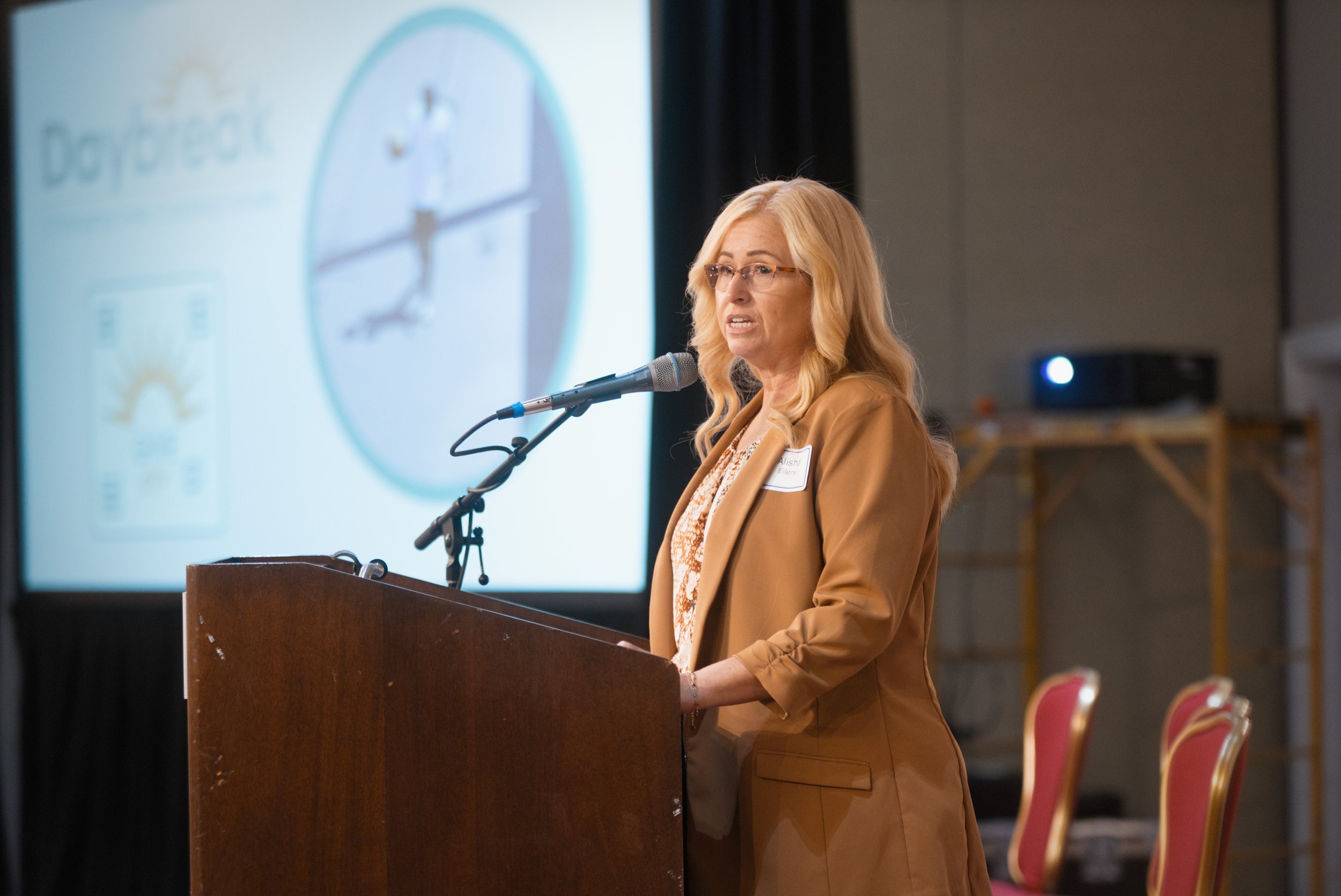 Professional photographers capture keynote speaker, nonprofit organization president in dynamic lighting and shallow depth of field.