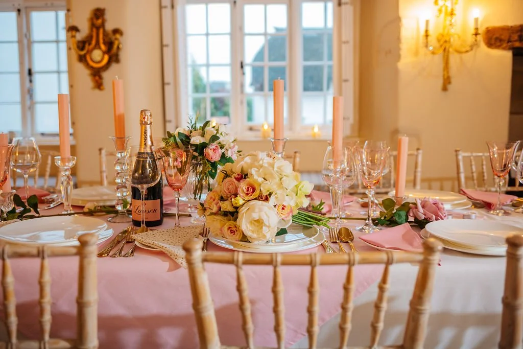 A prepared wedding breakfast set up in a cosy and charming intimate wedding venue room with beautiful candles, cutlery and flowes