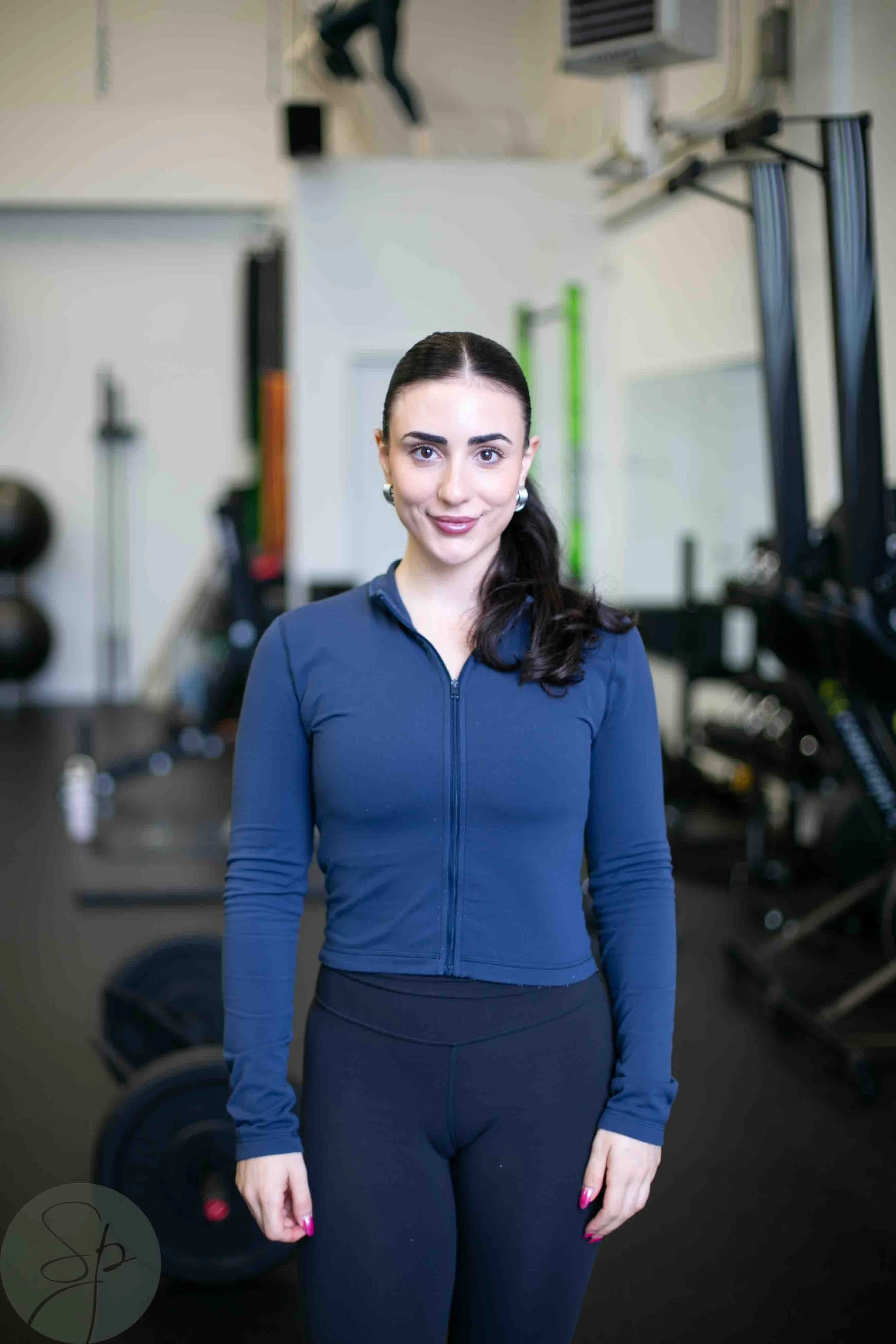 Woman in workout attire standing in a gym