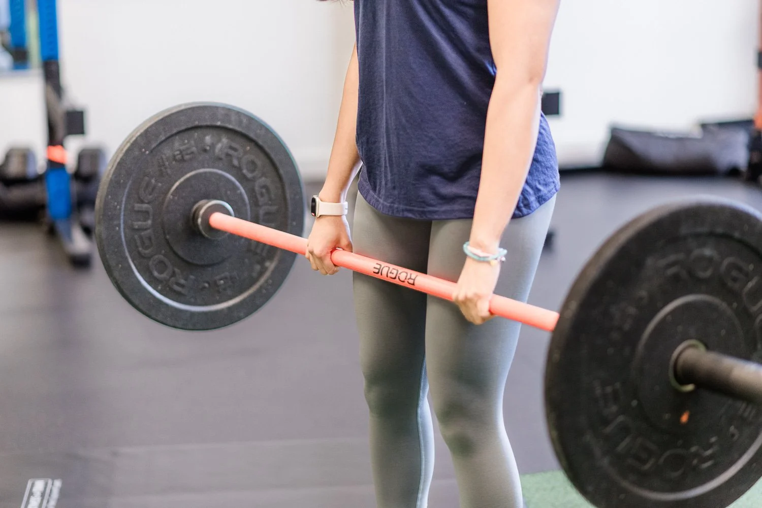 woman doing deadlift with barbell in gym functional training