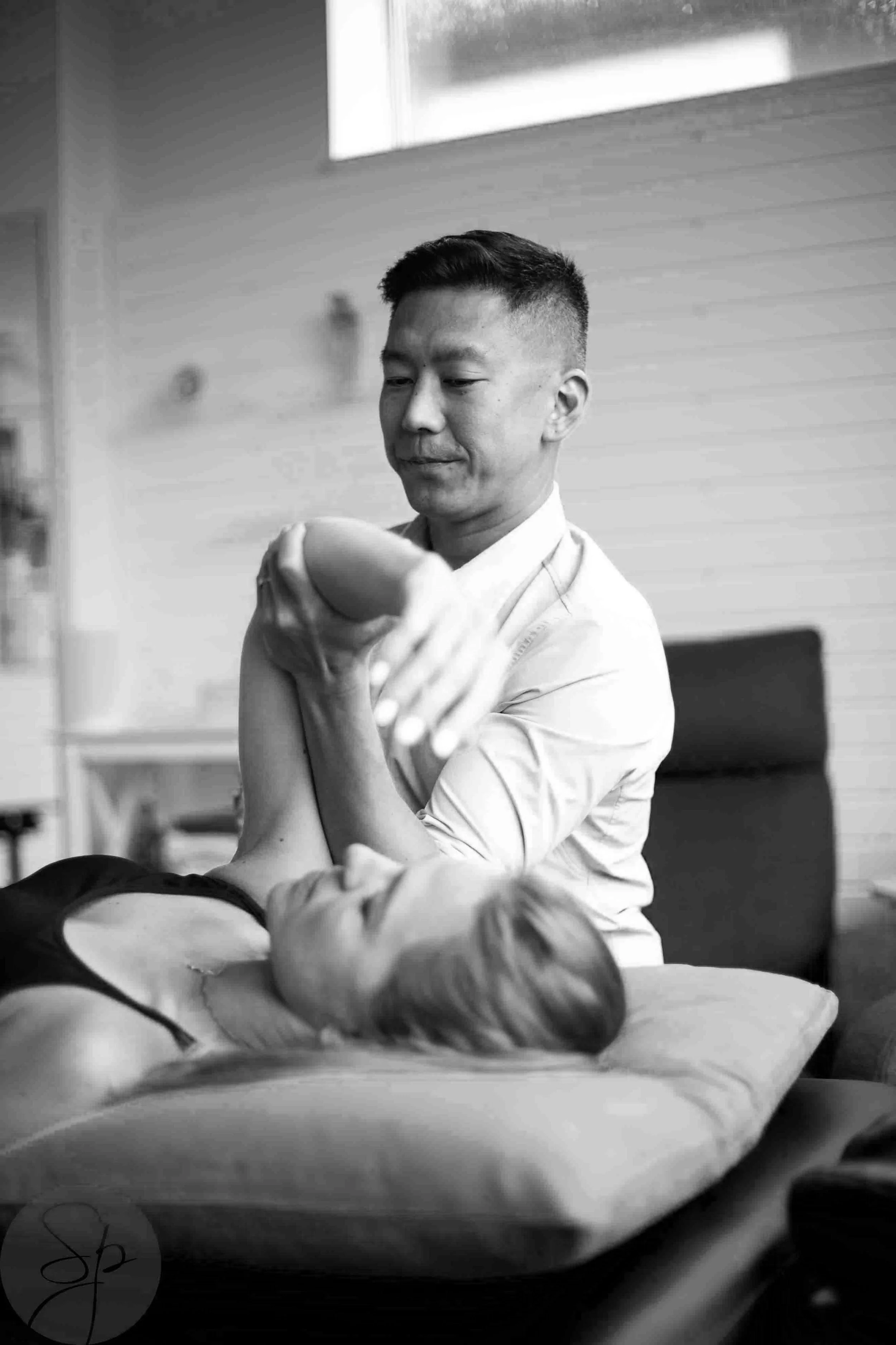 Physiotherapist assisting a woman with arm exercise