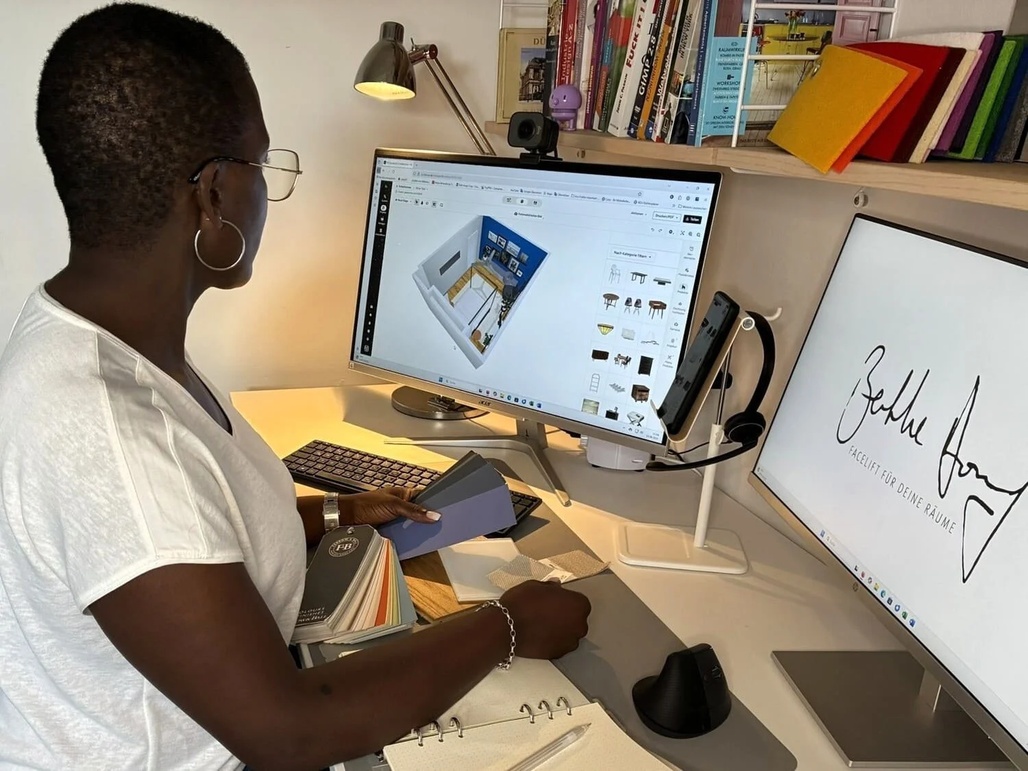 Frau arbeitet an einem Computer mit zwei Bildschirmen, eine zeigt einen 3D-Raumplan, die andere einen weißen Bildschirm mit schwarzer Schrift, Bücherregal im Hintergrund.