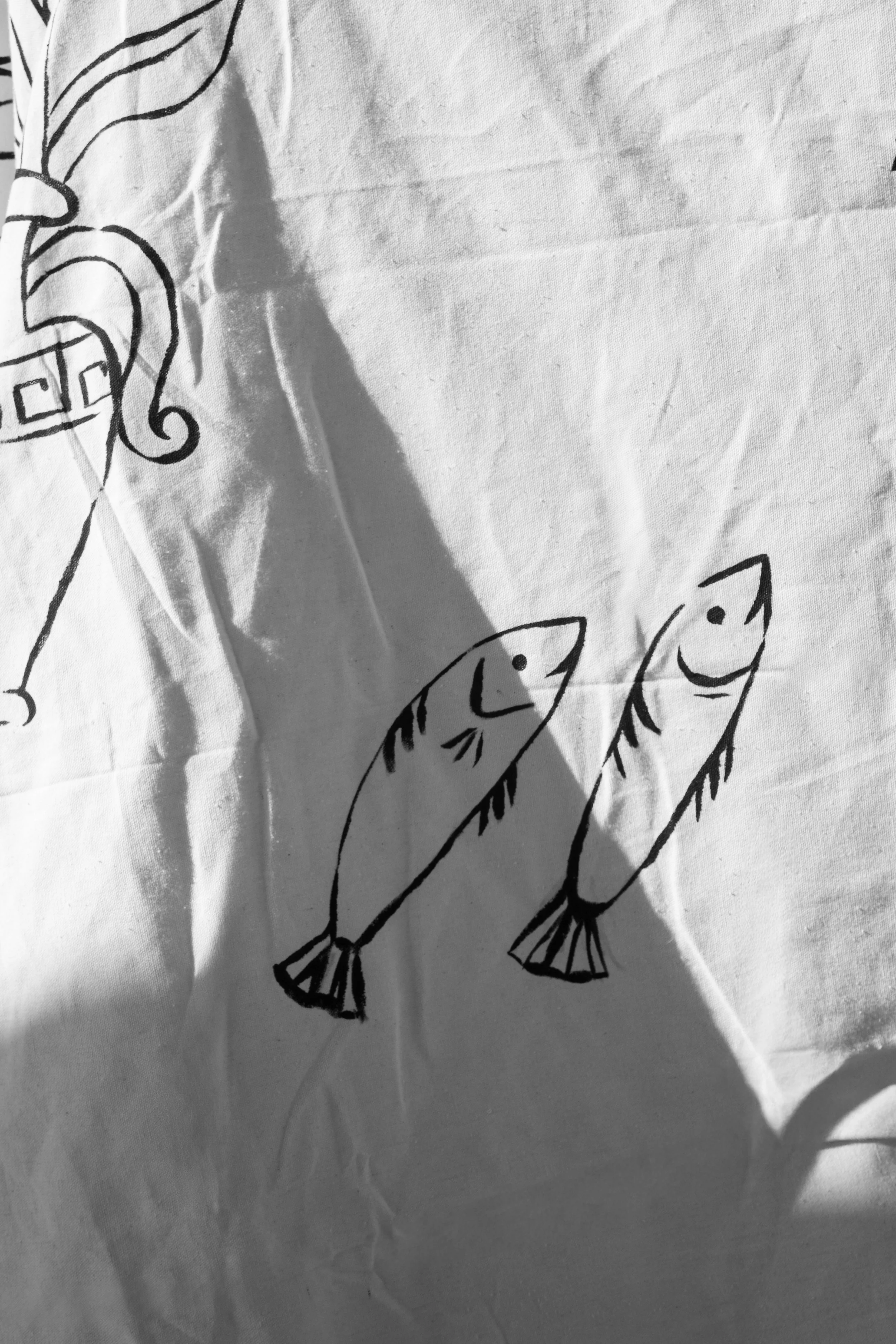 Close up of line drawing with Greek imagery like two fish