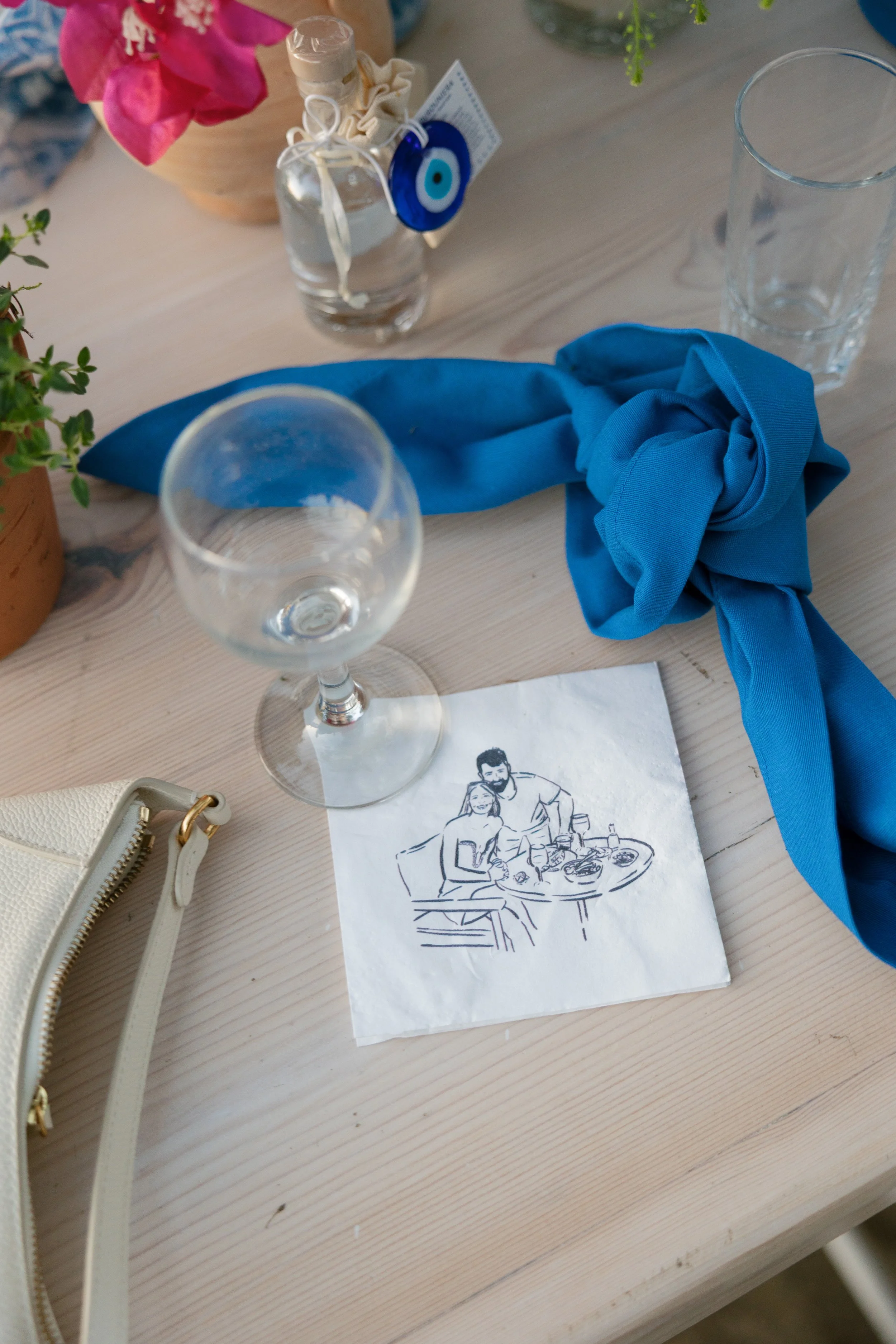A table setting with a custom drawing of a bride and groom on a cocktail napkin
