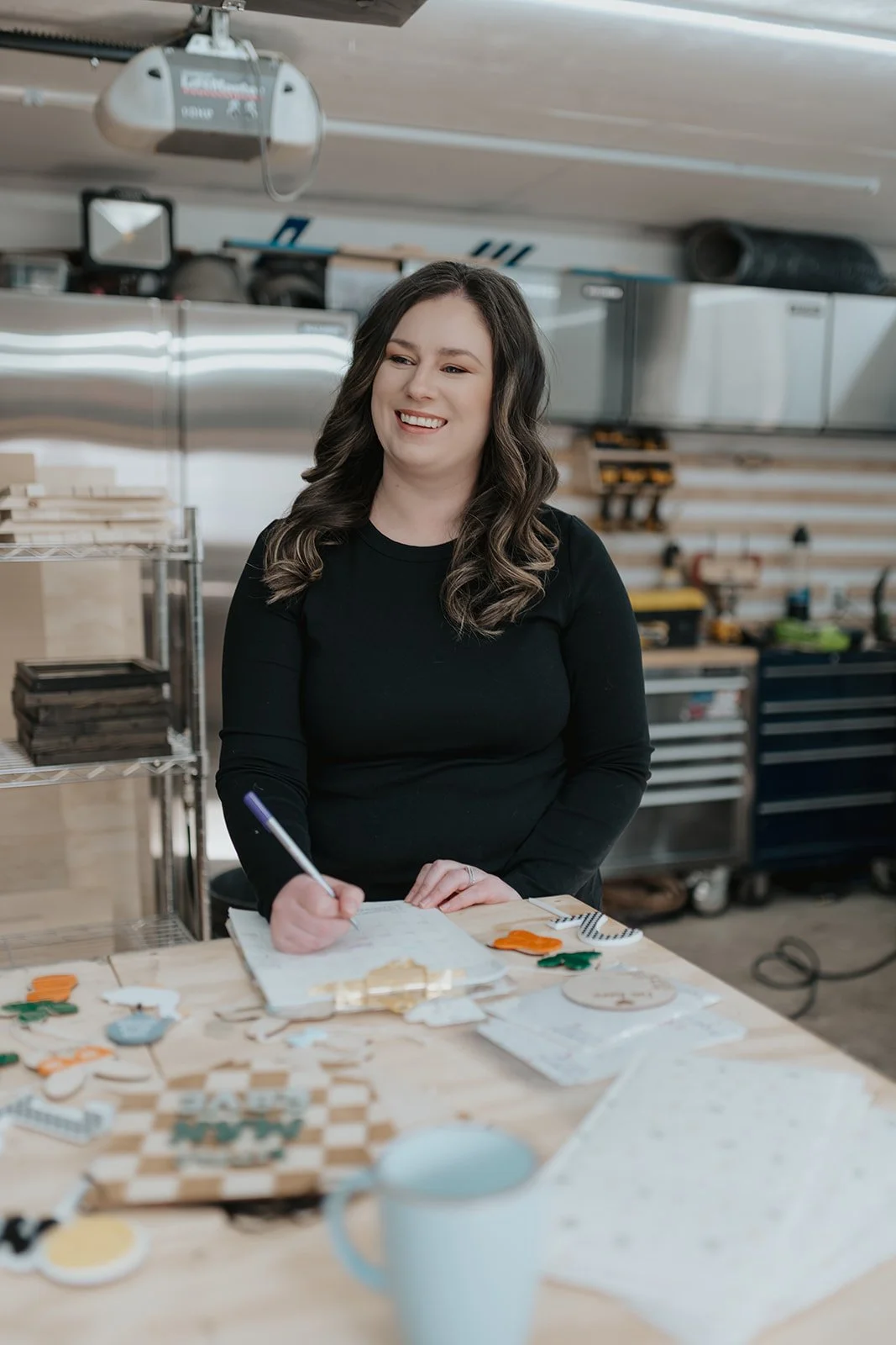alysha smiling while holding pen to write on paper