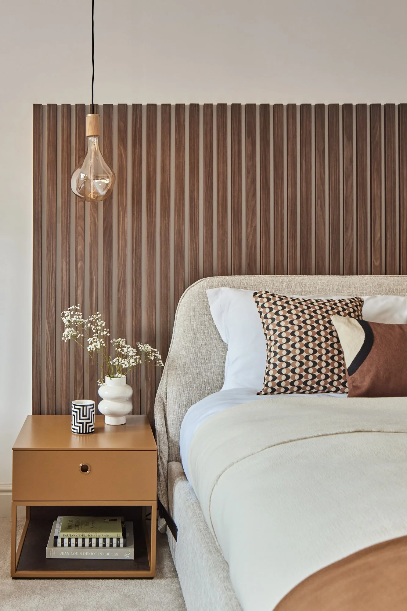 Wimbledon contemporary bedroom with wooden paneling, neutral bedding, and decorative accents.