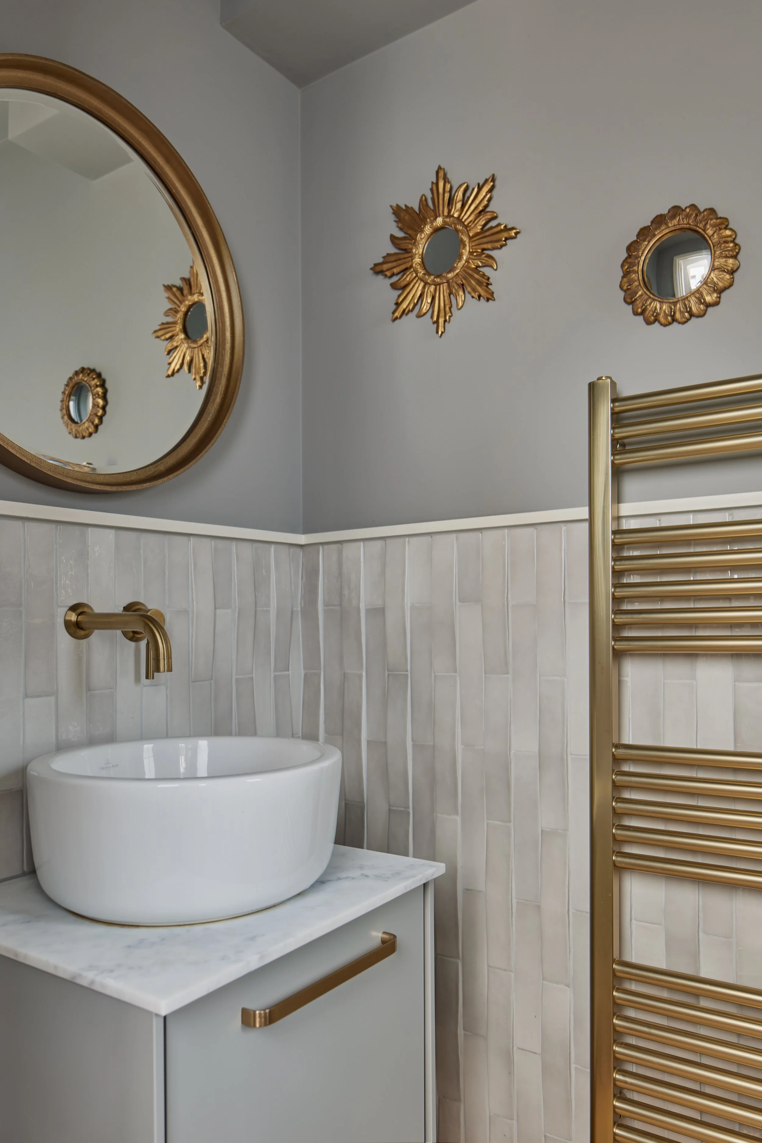 Elegant guest bathroom with gold fixtures in our Wimbledon project