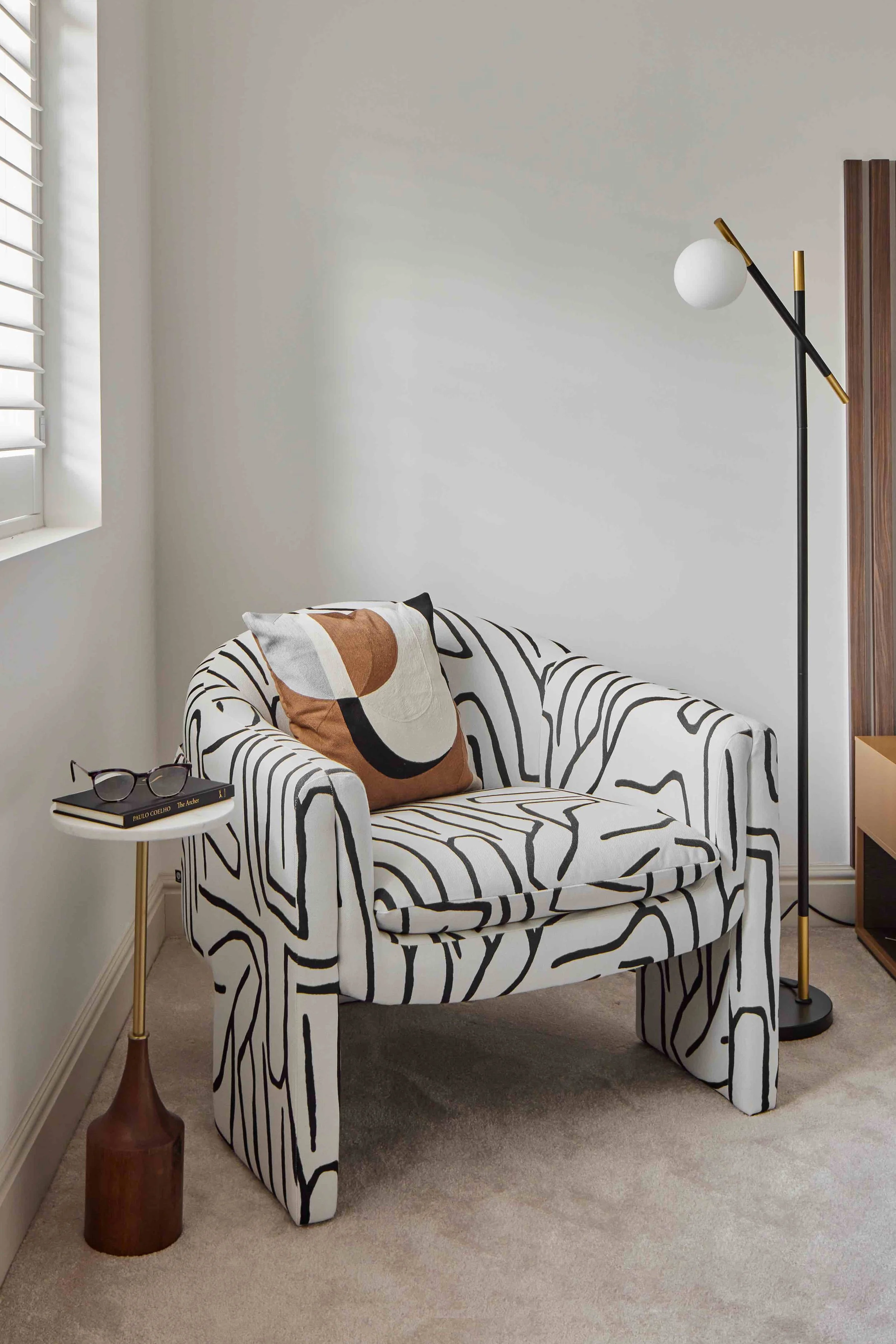 black and white accent chair in black floor lamp with gold details