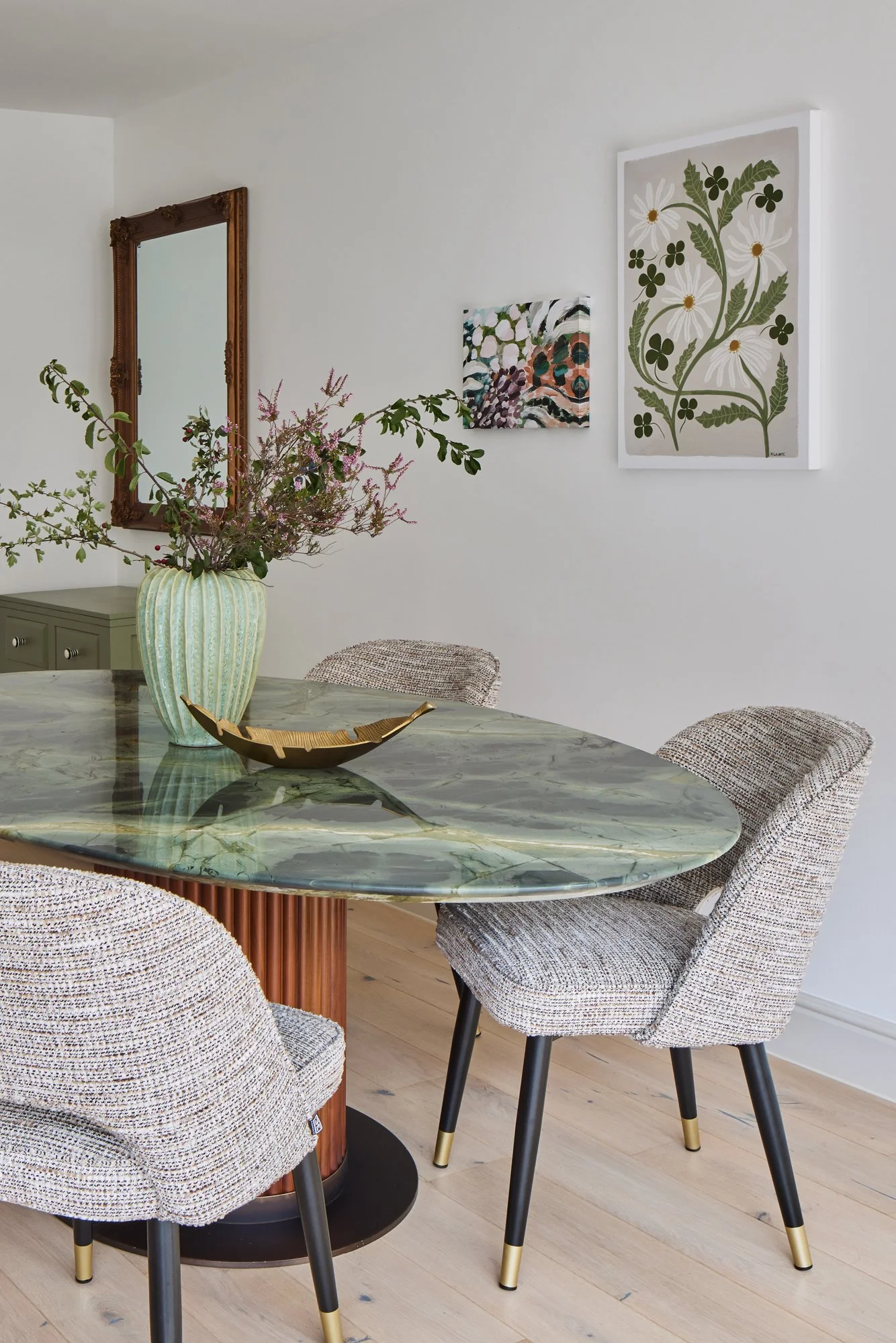 Wimbledon dining room interior with green marble table, contemporary chairs, and decorative accents.