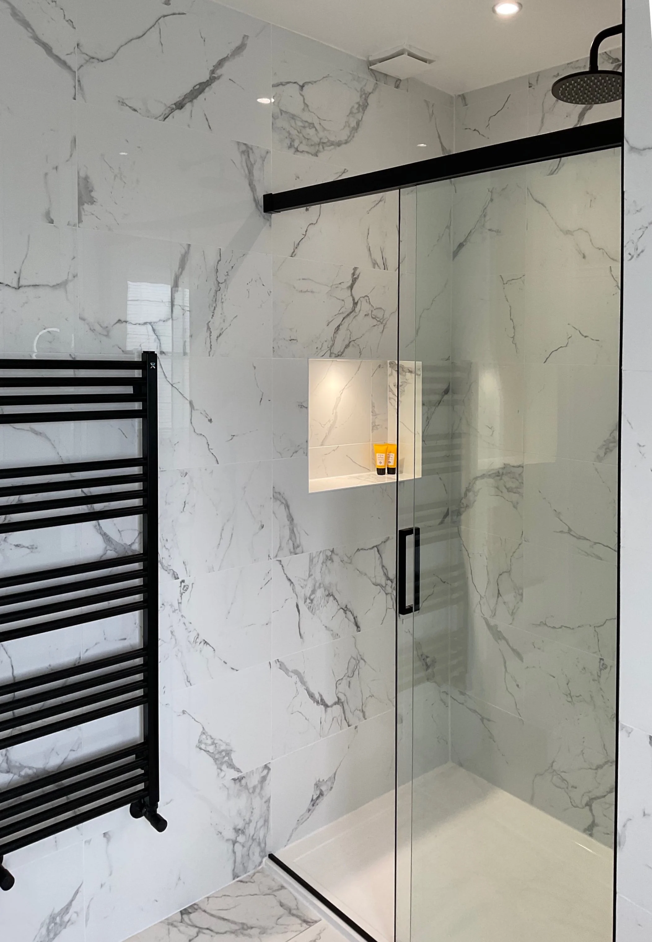 Contemporary bathroom interior in Cobham featuring a marble shower area with sleek fixtures and modern design. A stylish and functional space combining luxury materials with minimalist elegance.