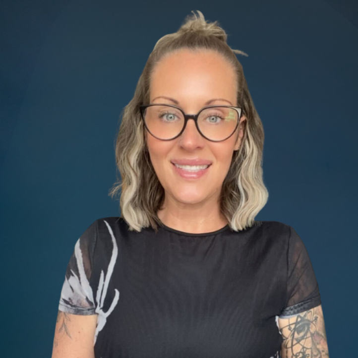 Woman smiling with glasses and tattoos