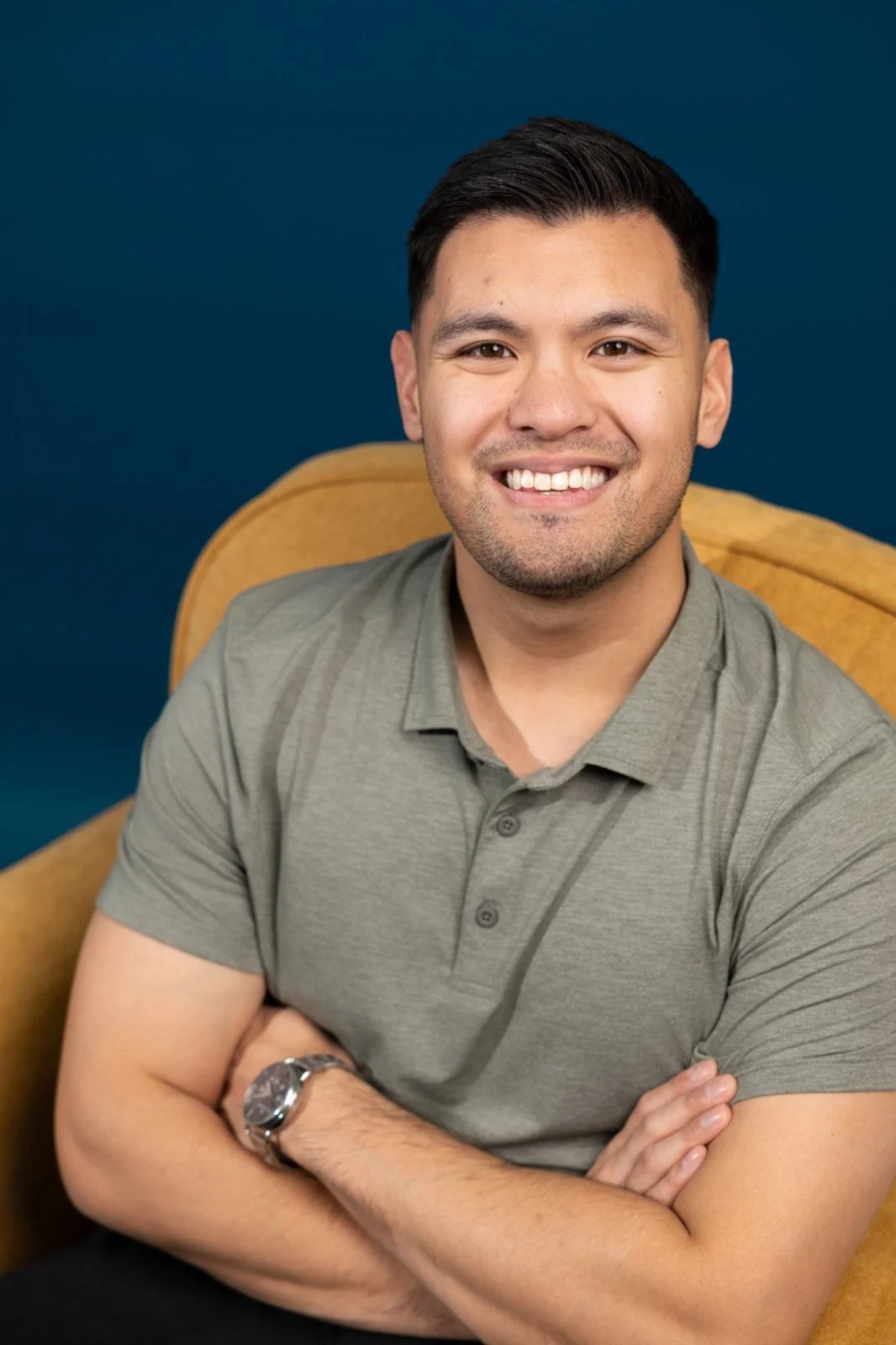 Man with dark hair in dress shirt smiling