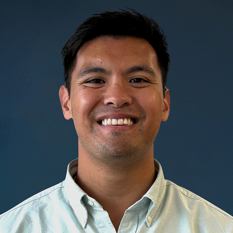 Man with dark hair in dress shirt smiling 