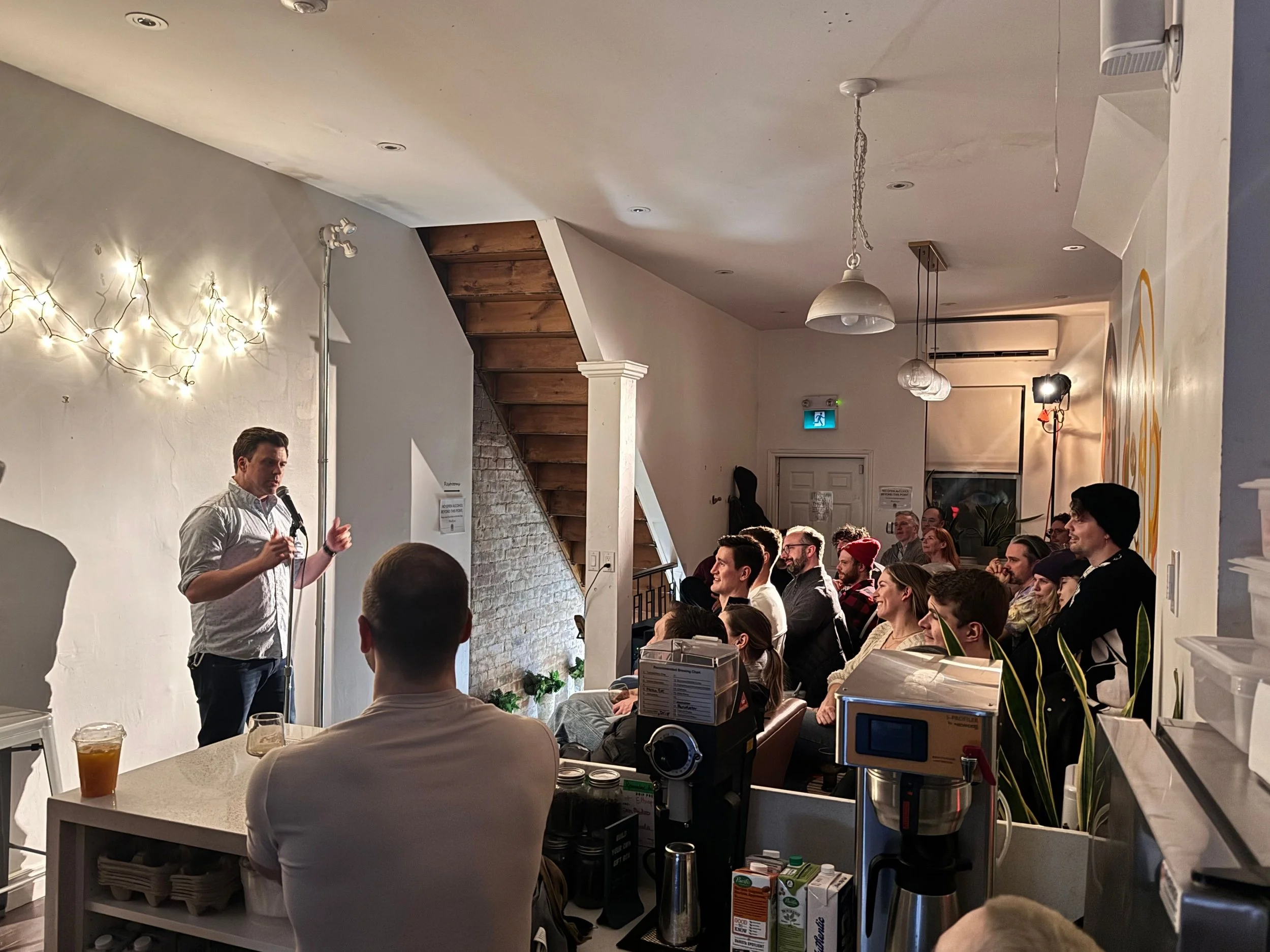 A comedian at a microphone during a comedy night hosted at Morning Parade's Upper Beaches cafe.