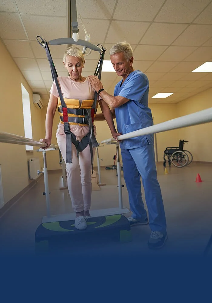 Physical therapist helping an older adult patient improve walking, strength, balance, and mobility during rehabilitation