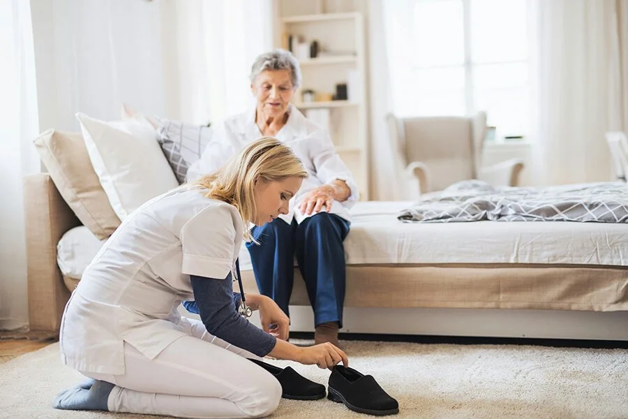 Home health aide assisting a patient with daily activities, representing in-home care services from North Runnels Hospital District.