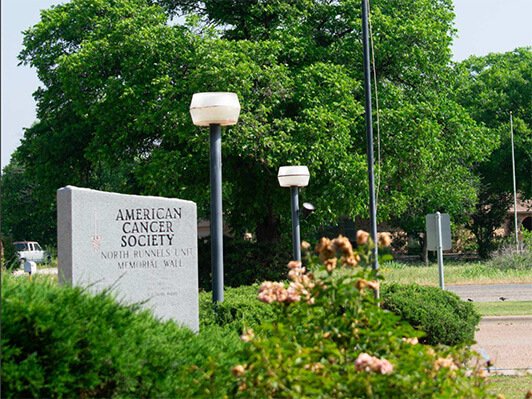American Cancer Society North Runnels Unit Memorial Wall surrounded by landscaping in the North Runnels community.