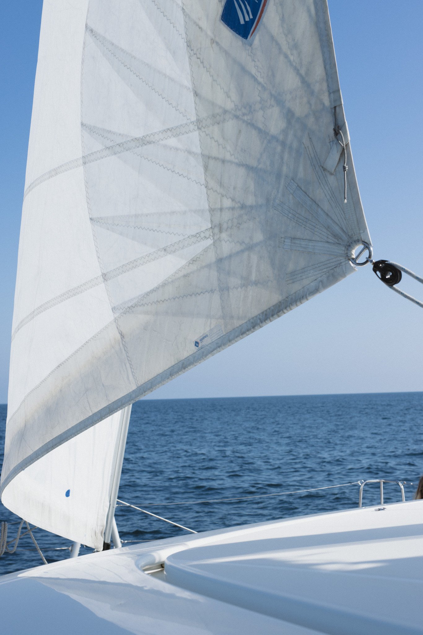 A person with one foot on a tennis court, holding a tennis racket, wearing white sneakers with red lettering, and murky image quality.