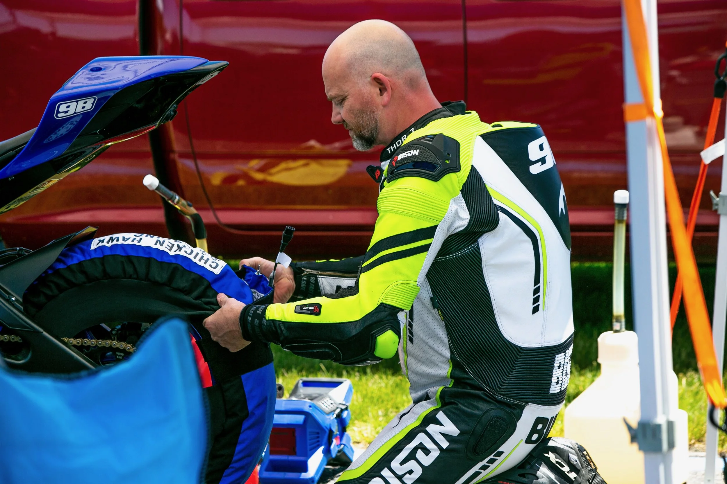 wes Burke in bison track suit putting on a tire warmers
