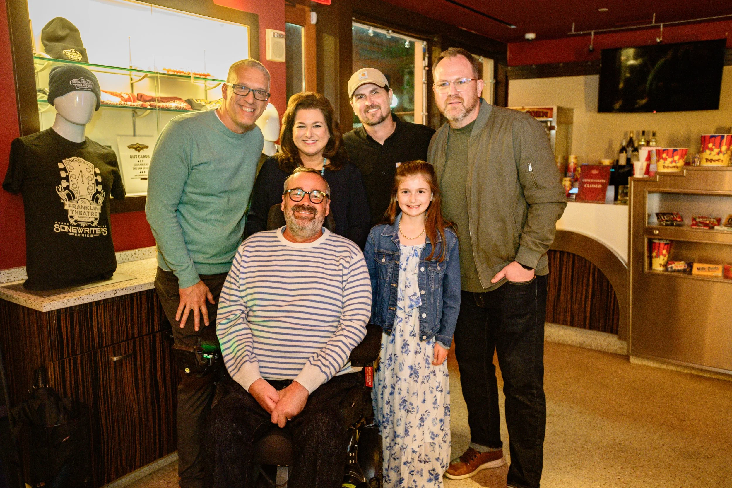 A group of people, one in a wheelchair, gathered together for a picture