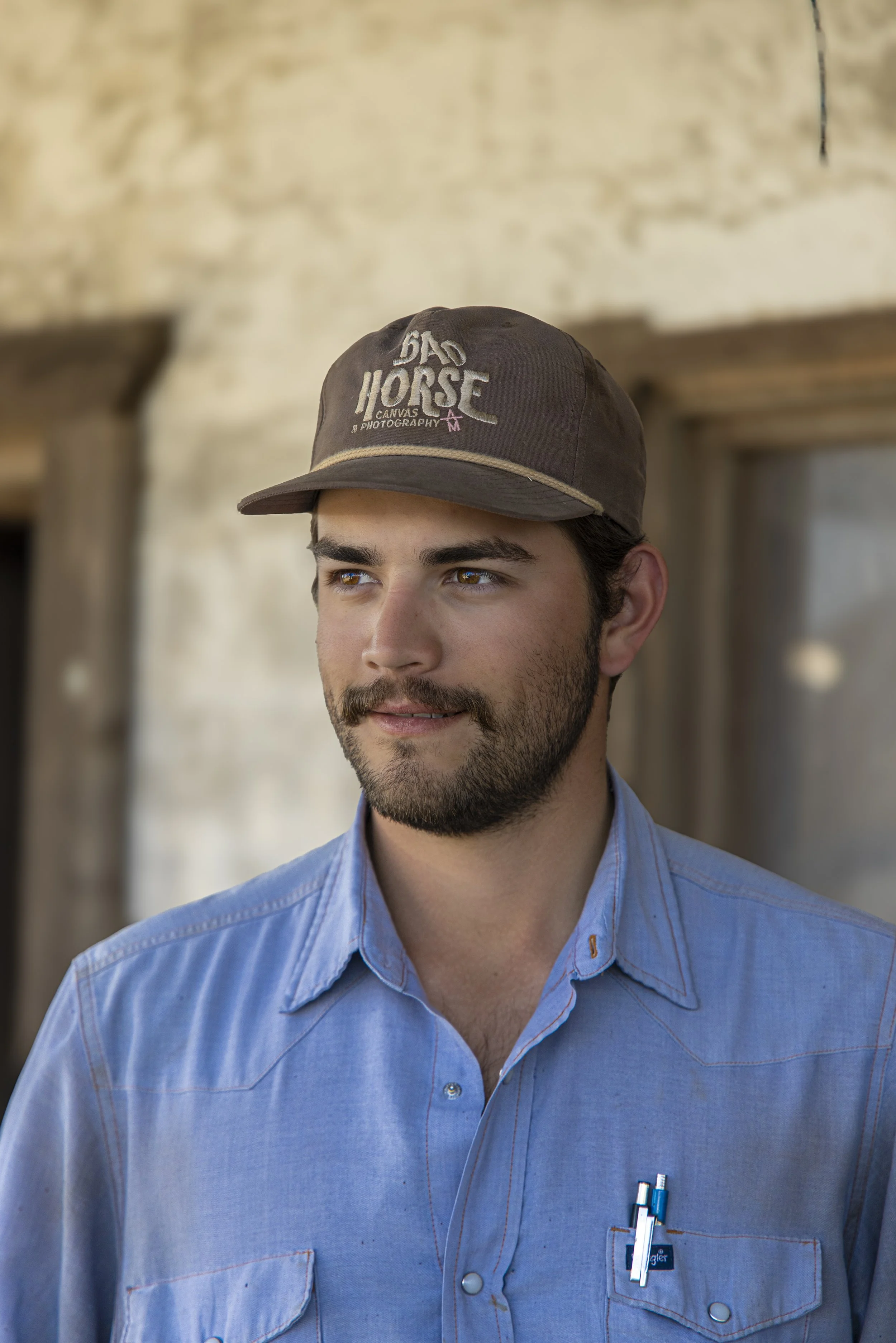 Man wearing brown cap with Badhorse logo cap