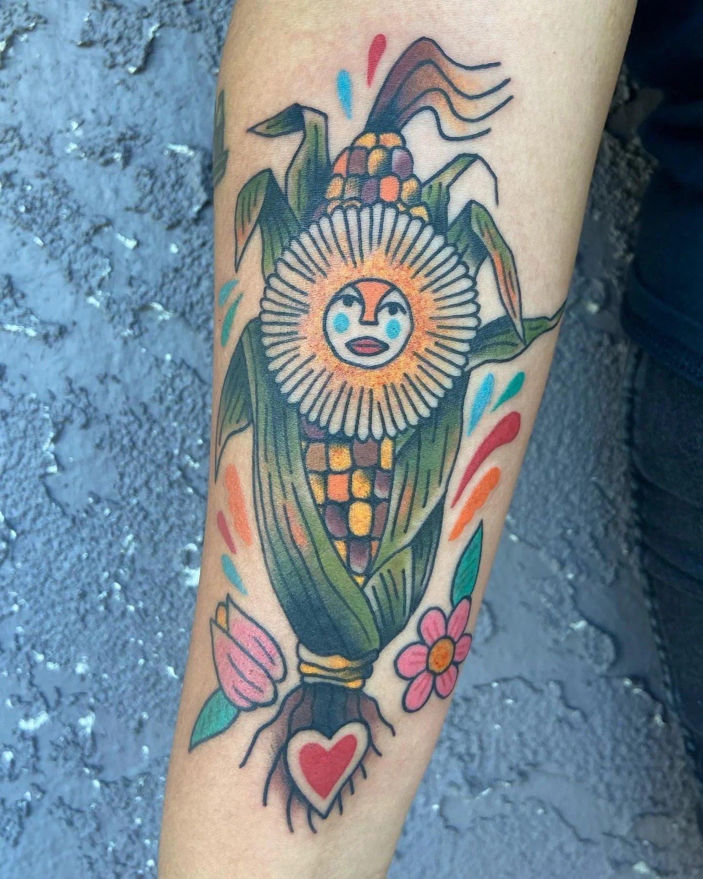 A colorful folk-inspired corn tattoo on a person's arm.