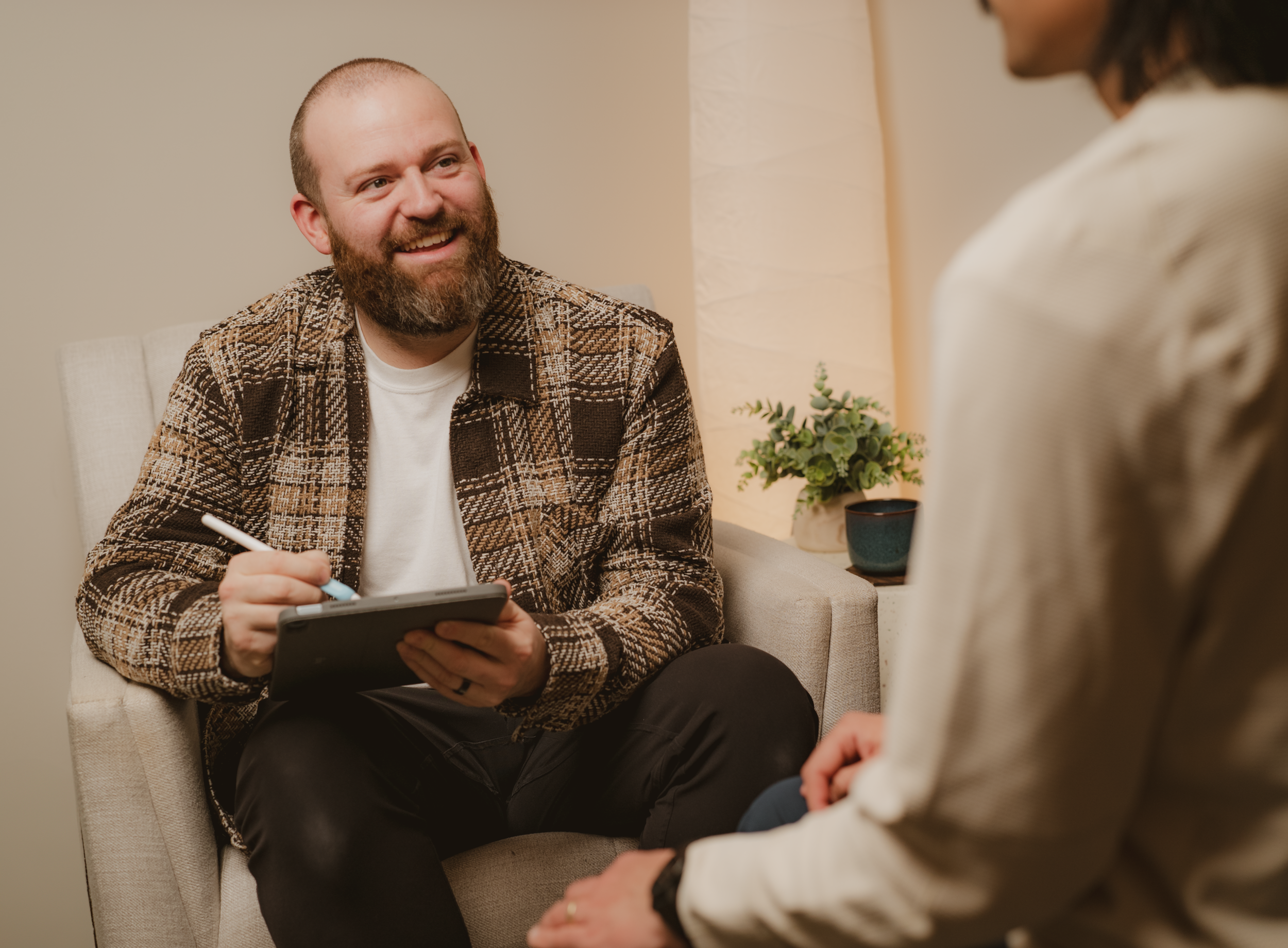 A male therapist with a kind smile provides therapy to a client