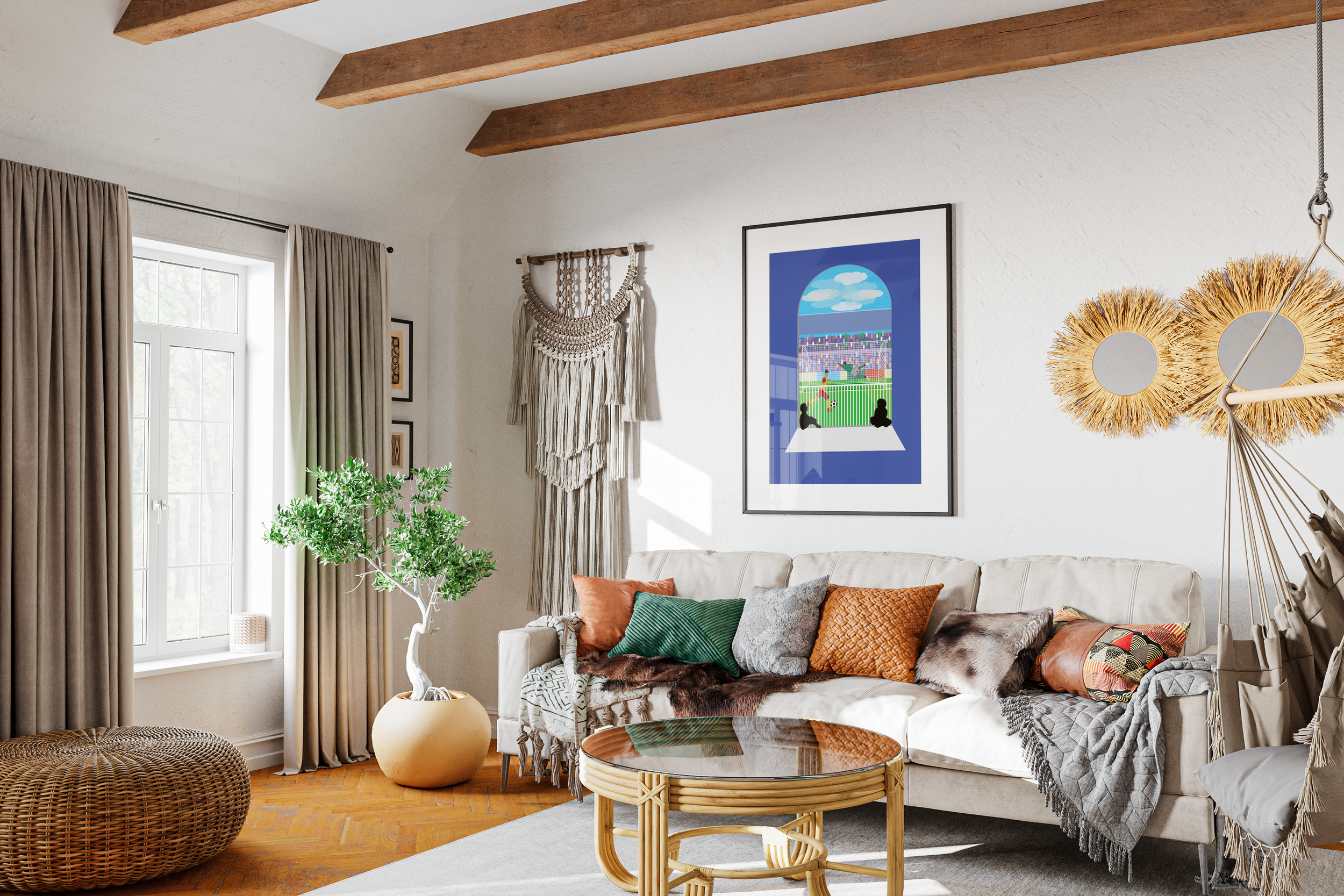 A cozy living room with a beige sofa decorated with colorful pillows and a throw, a round wicker coffee table, a potted plant near the window, and wall art including a framed picture of a baseball stadium viewed through a window, macrame wall hanging