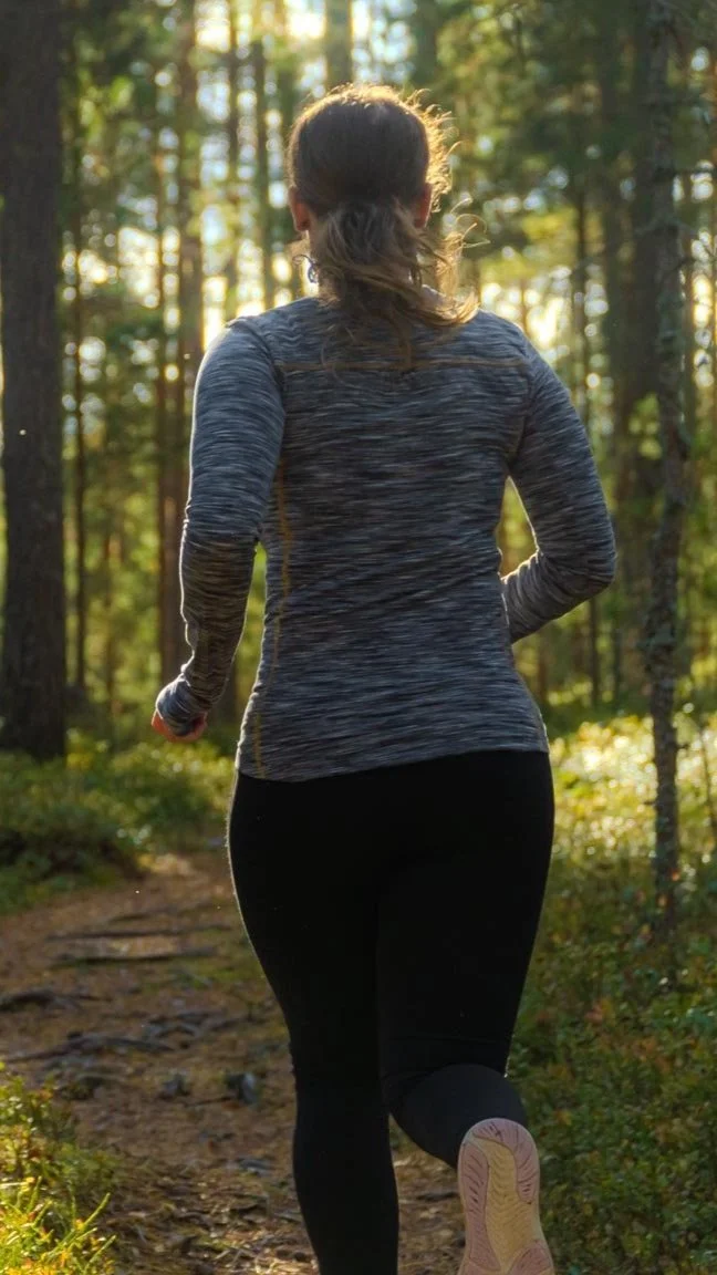 Rachel Collins High Performance Psychology Coach for Athletes running outside in the woods.