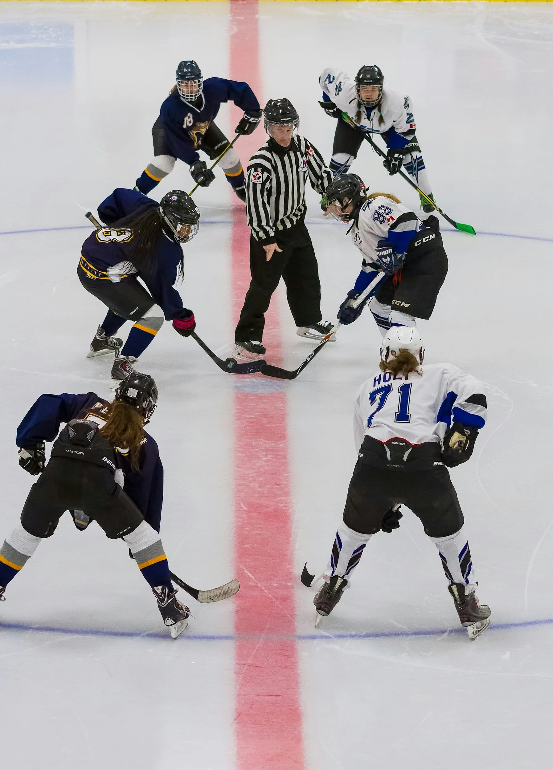 Photograph of ice-hockey team playing on the rink.