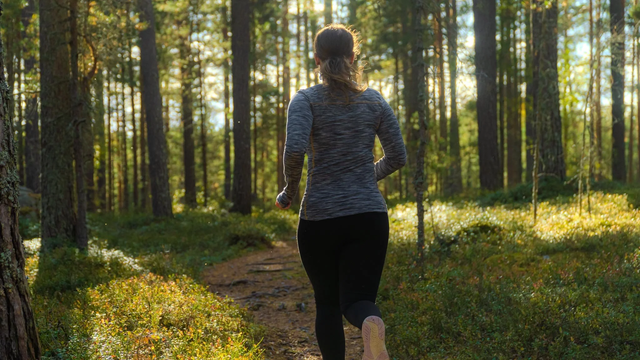 Photograph of Rachel Collins High Performance Psychology Coach for Athletes running outside in the woods.