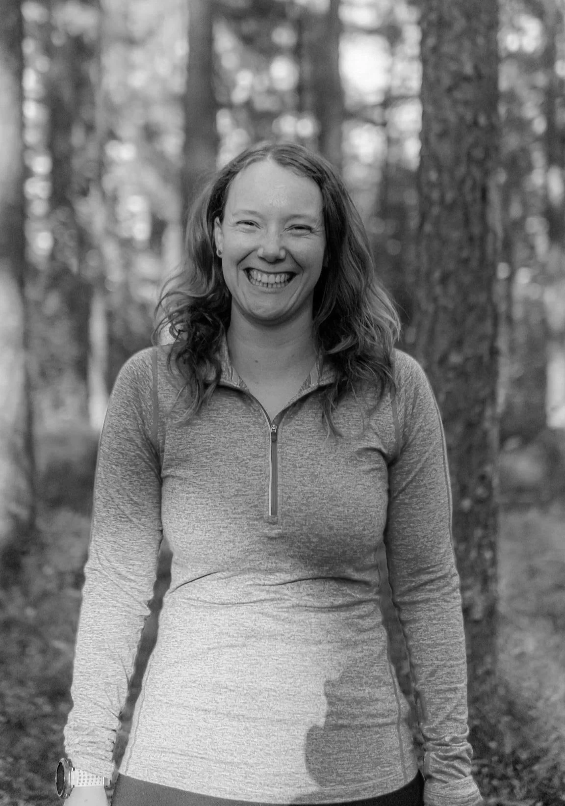 Black and white image of Rachel Collins High Performance Psychology Coach for Athletes outside in the woods