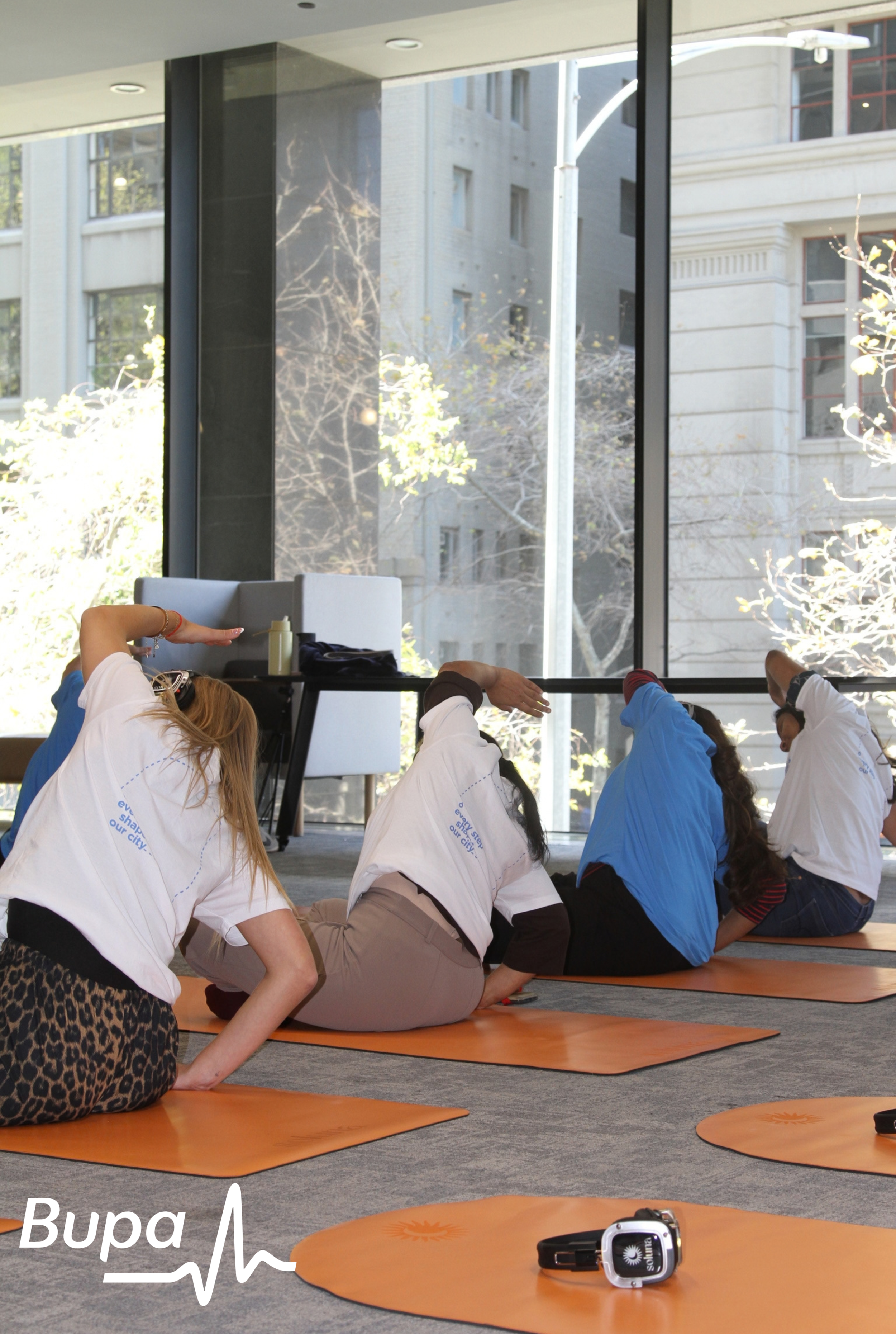 4 people stretching in a corporate yoga class
