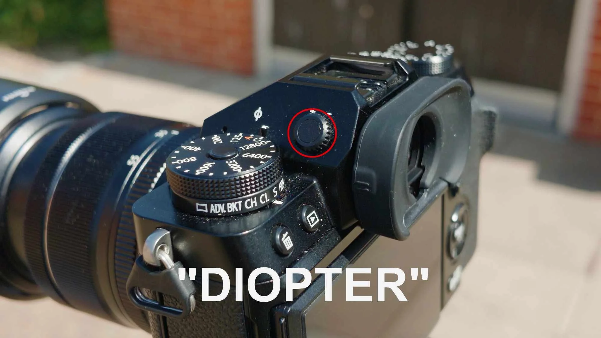 Close-up of a camera’s viewfinder, with the diopter adjustment dial highlighted in red.