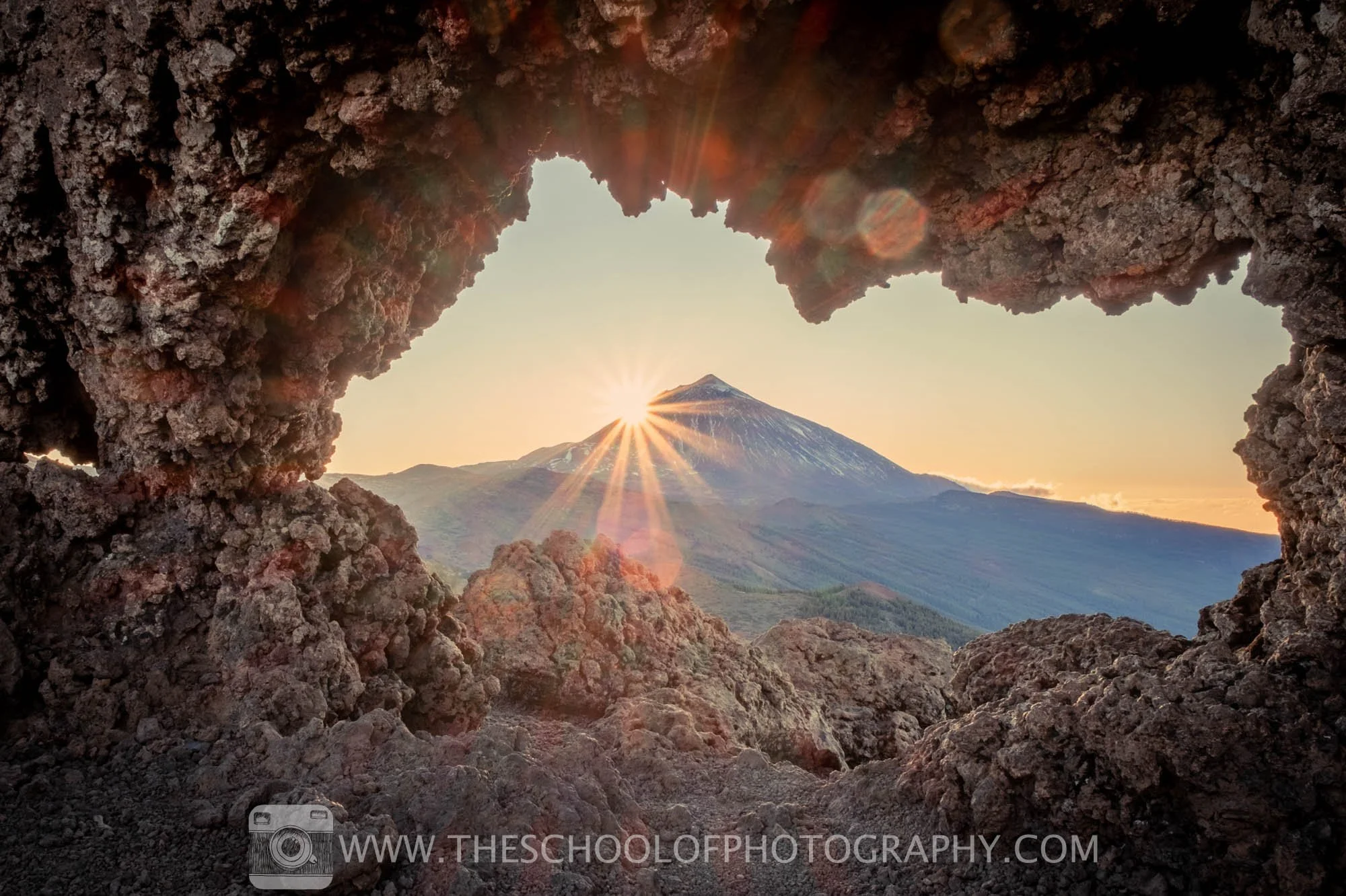 hdr bracketed image of sunburst over a mountain top through rocks