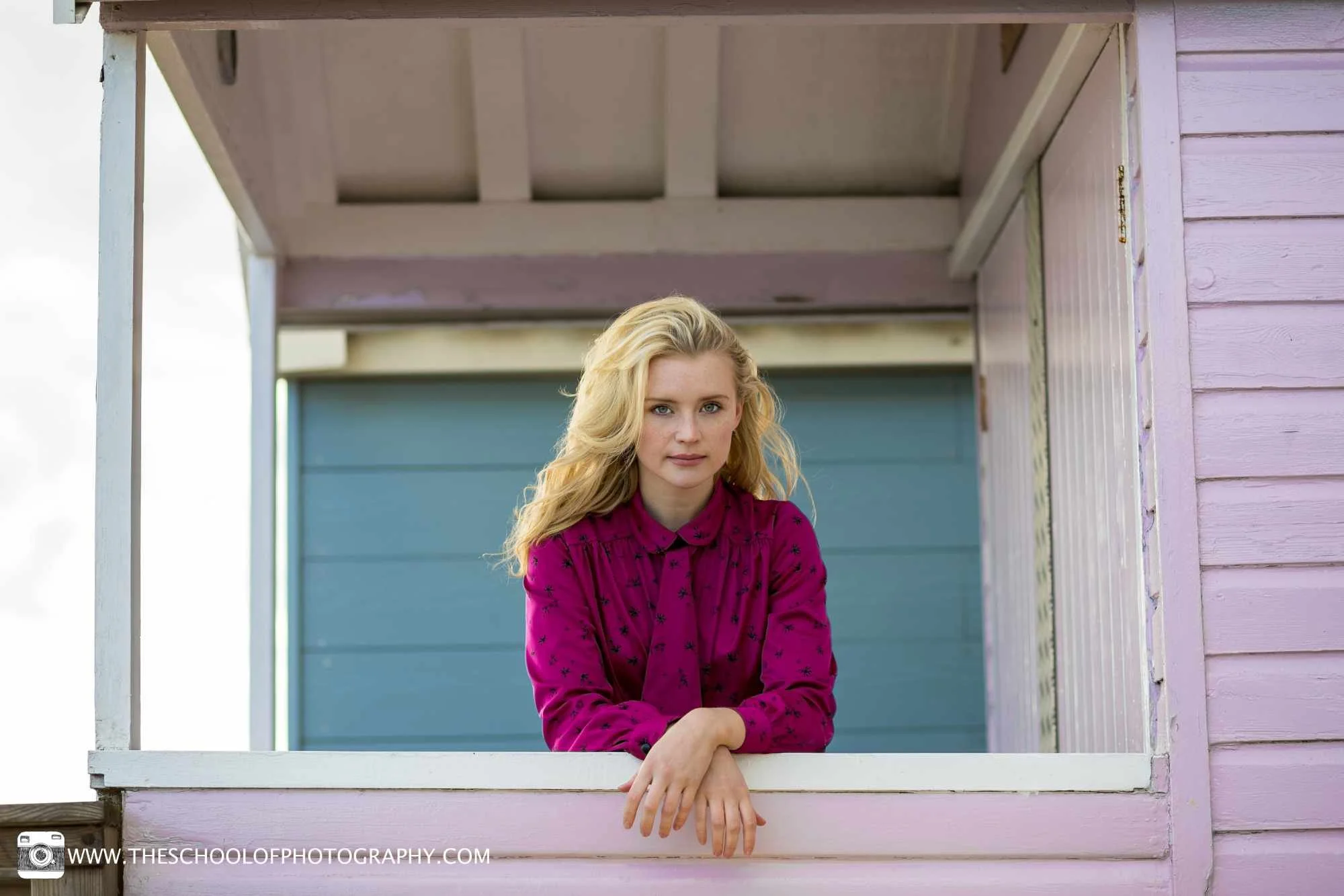 Portrait photography composition using a beach hut window to frame a woman