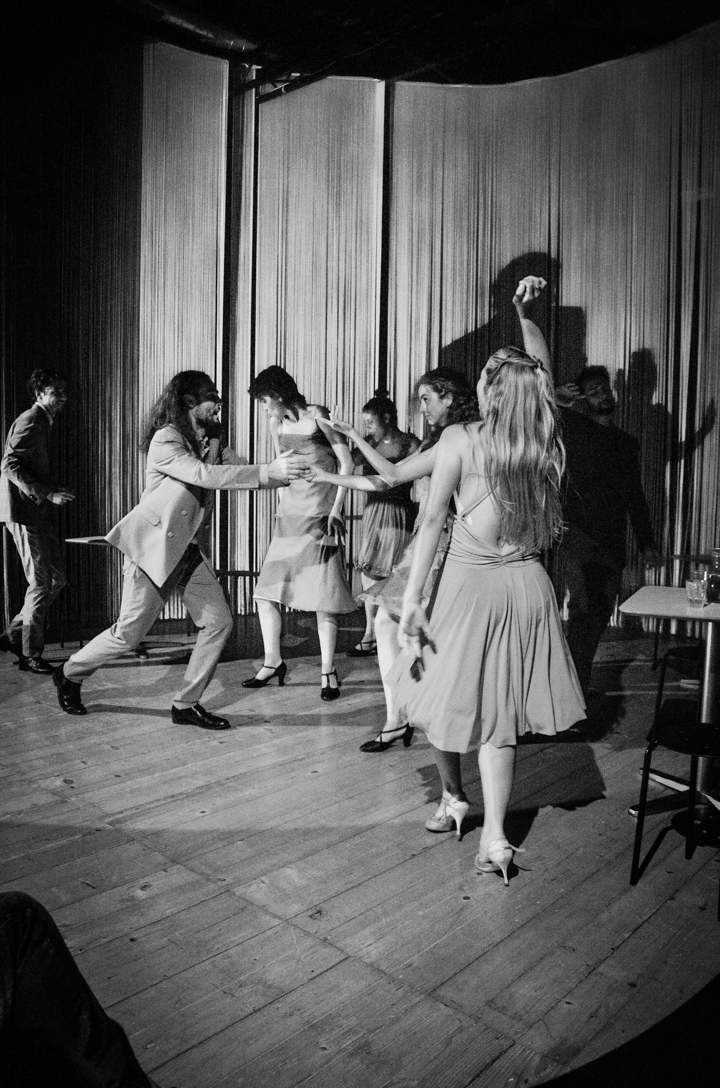 Persone che ballano e si divertono in una stanza, indossando abiti eleganti, in un evento o festa.