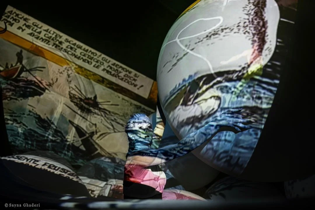 Installazione artistica composta da sfere e pannelli con immagini e testi, riflettendo un ambiente di presentazione o mostra.