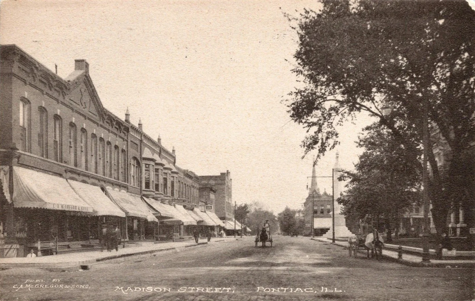 Postcard photograph shows McGregor & Sons Store on W. Madison Street on the corner of Mill Street in the left foreground