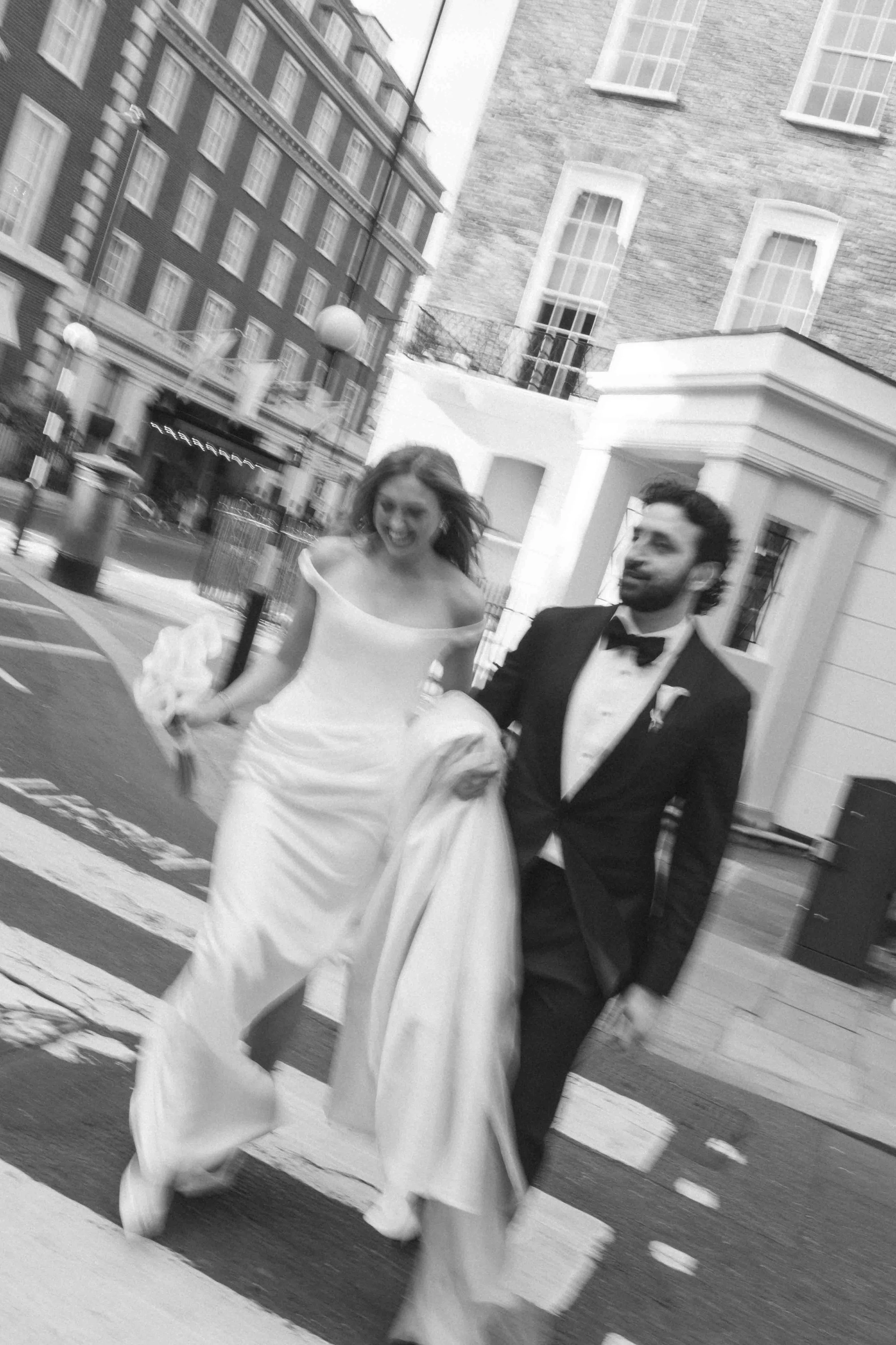 artistic blurry black and white photo of a bride and groom walking in Mayfair