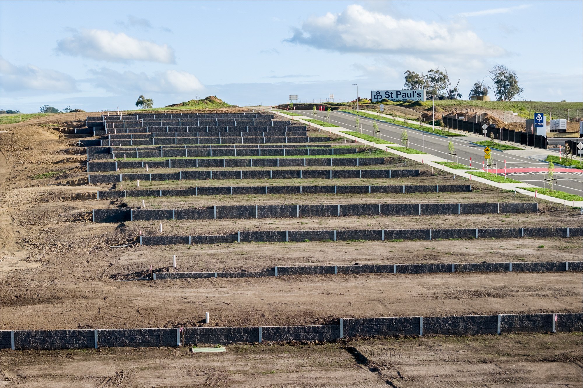 Construction photography terraced land development with retaining walls and prepared lots