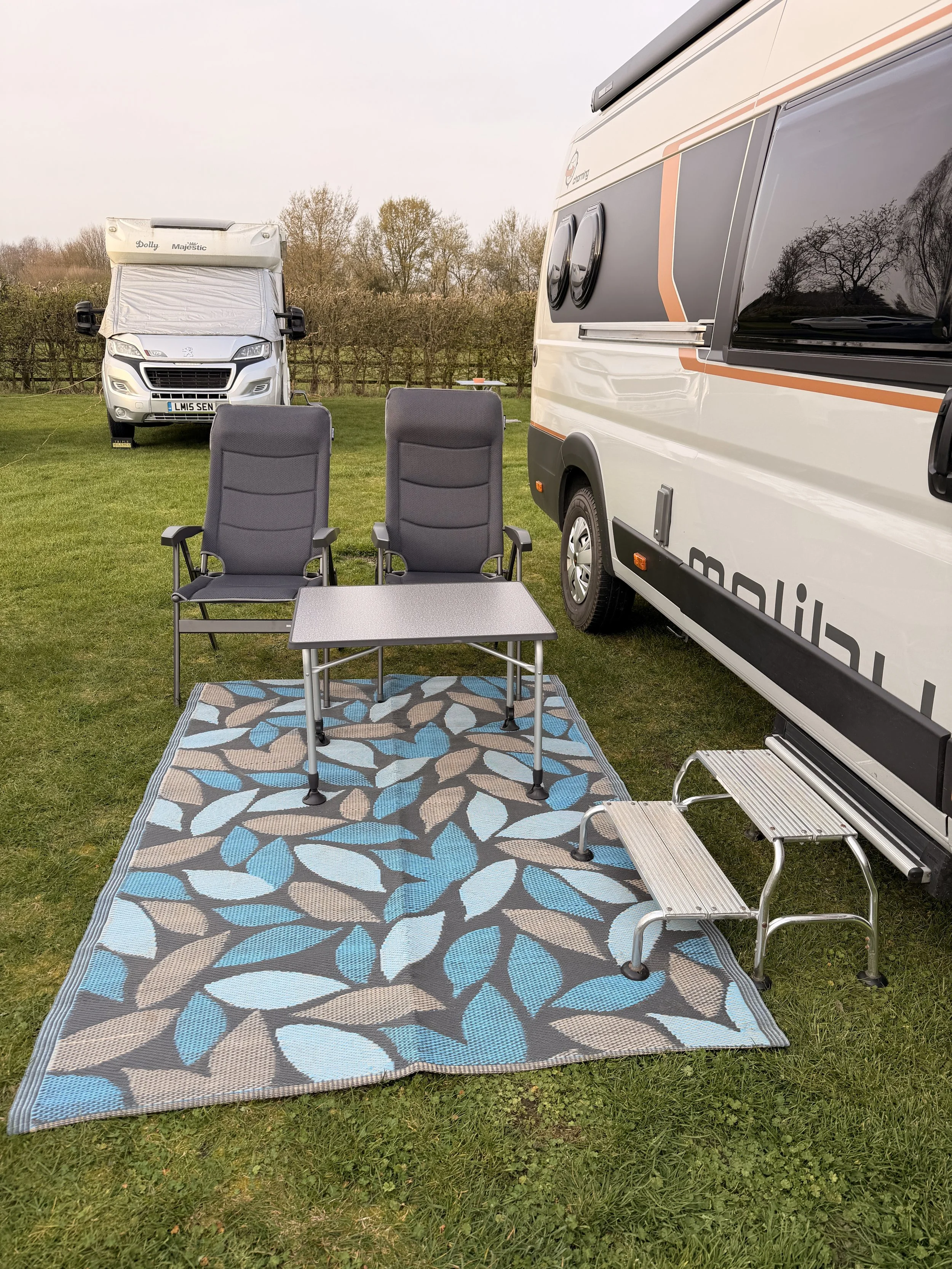 Where did they go?  Empty chairs, a table and a colourful outside rug.  