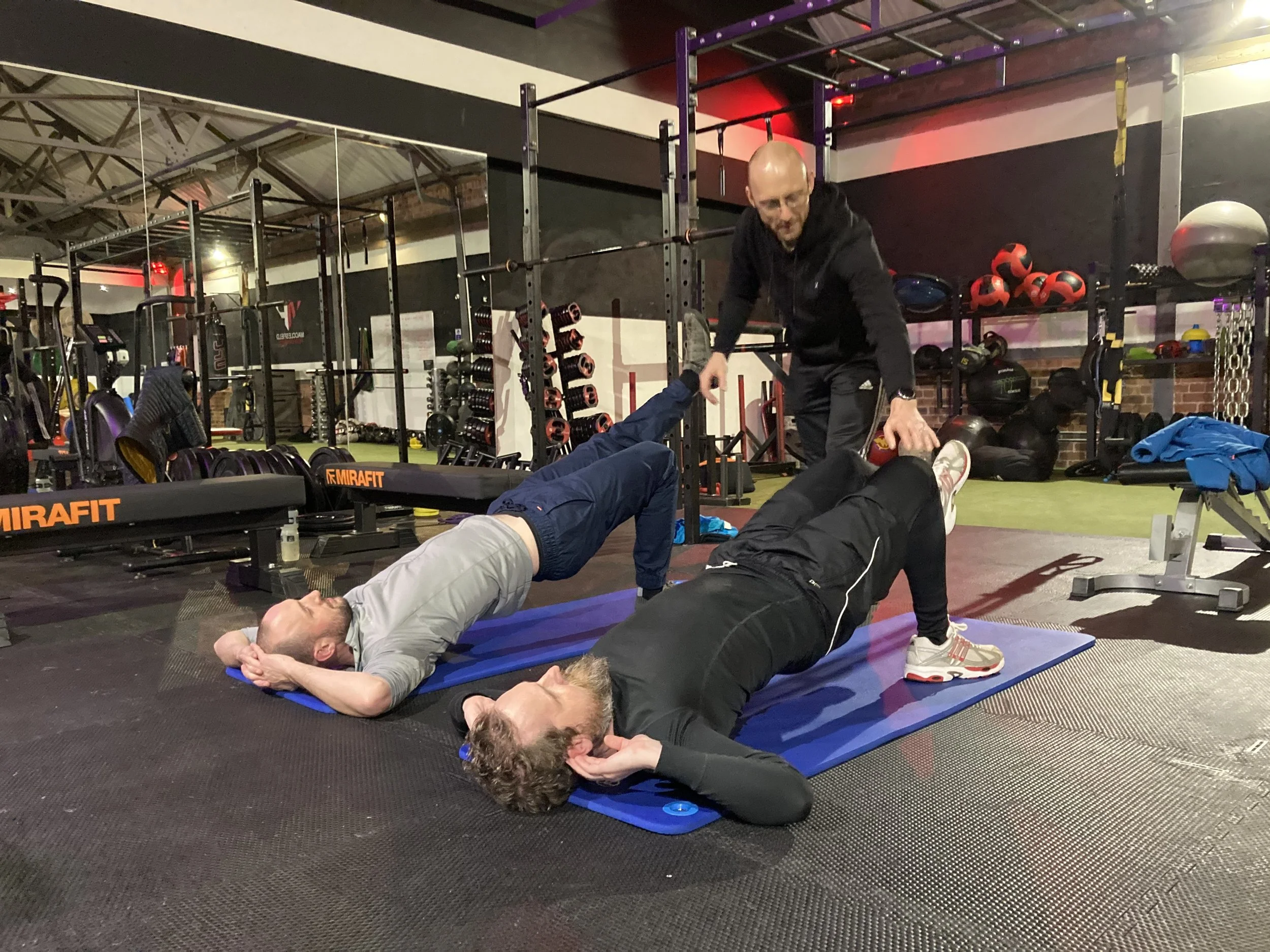 A personal trainer coaching two people
