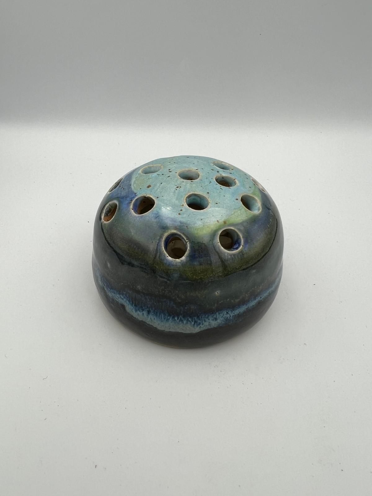 Een keramische stewardess met meerdere openingen en een glanzende, gekleurde afwerking.