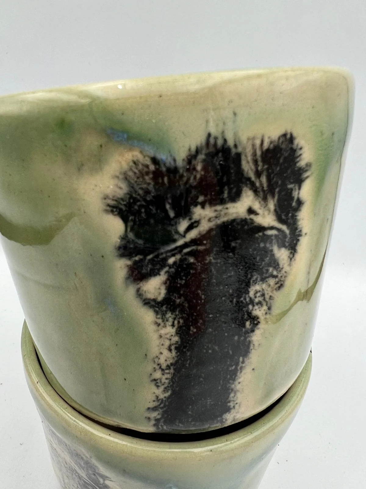 Close-up van een vaas met een bloemmotief, ontworpen in een keramisch stijl, met een witte en groene glaze.